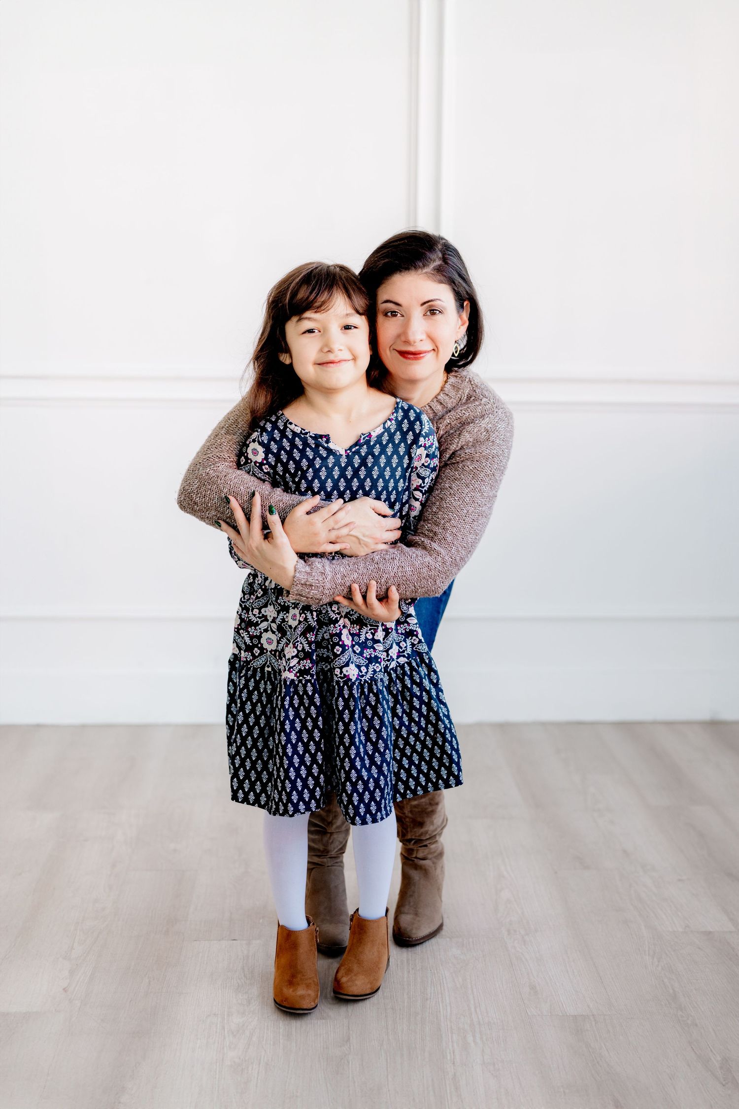 Two people share a warm embrace while wearing coordinating blue and brown outfits.