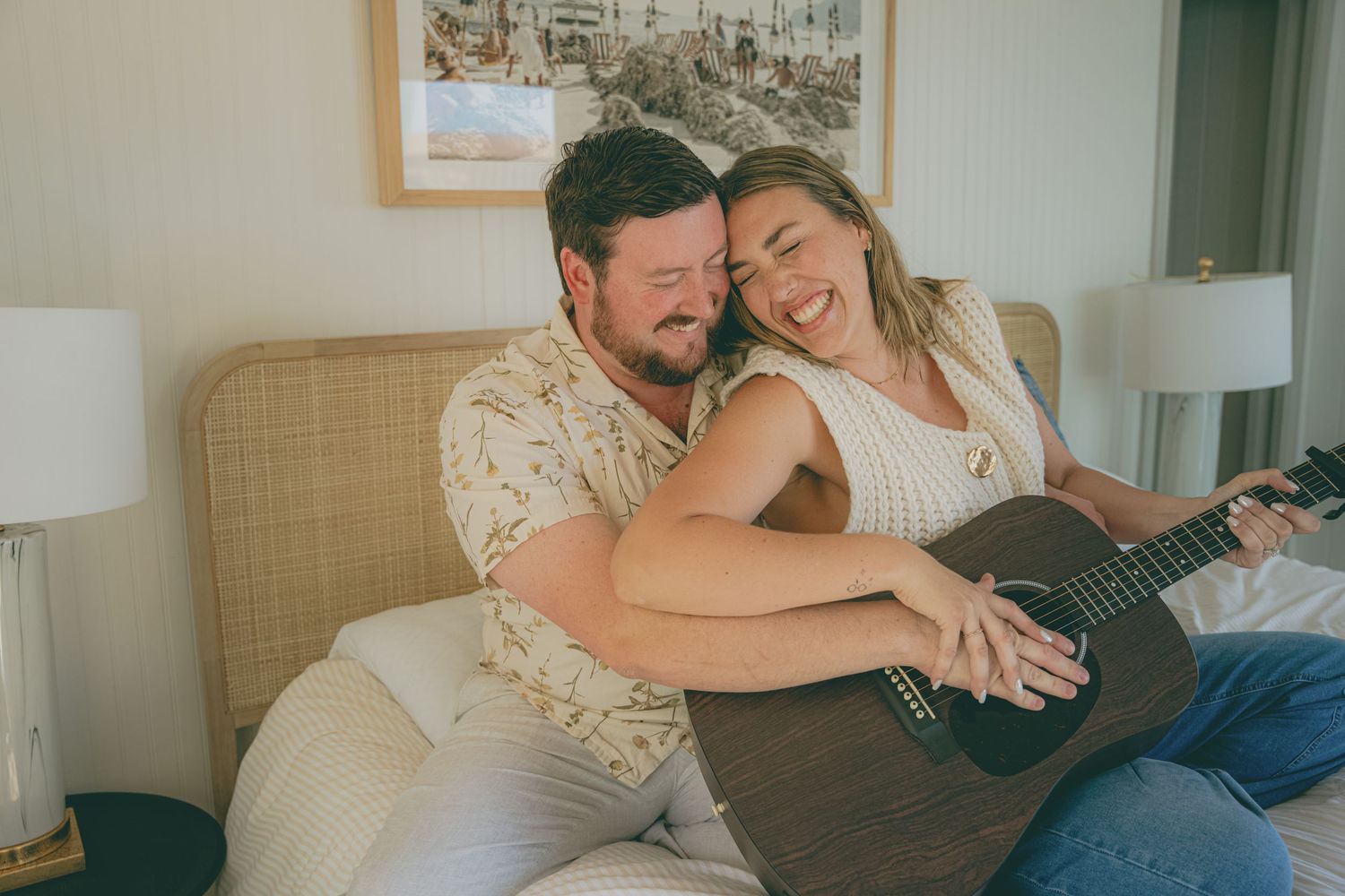A couple relaxes together on a couch while looking at a digital tablet in their living room.