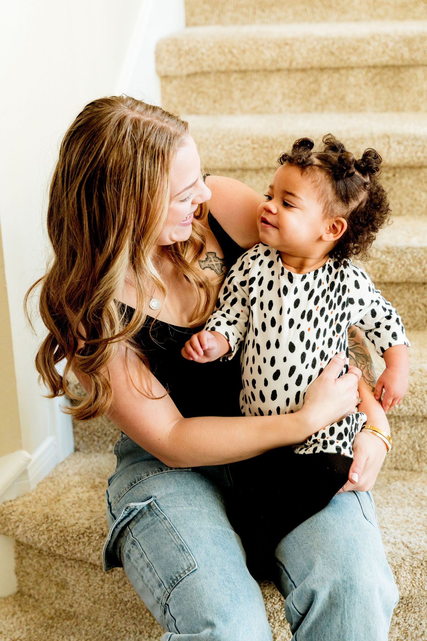 Candid laughing moment captured on beige carpeted staircase.