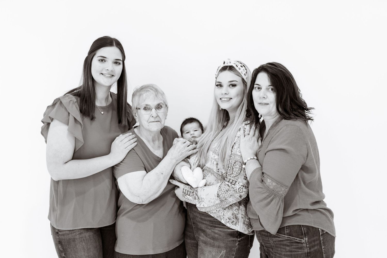 Black and white multi-generational family portrait against white background.