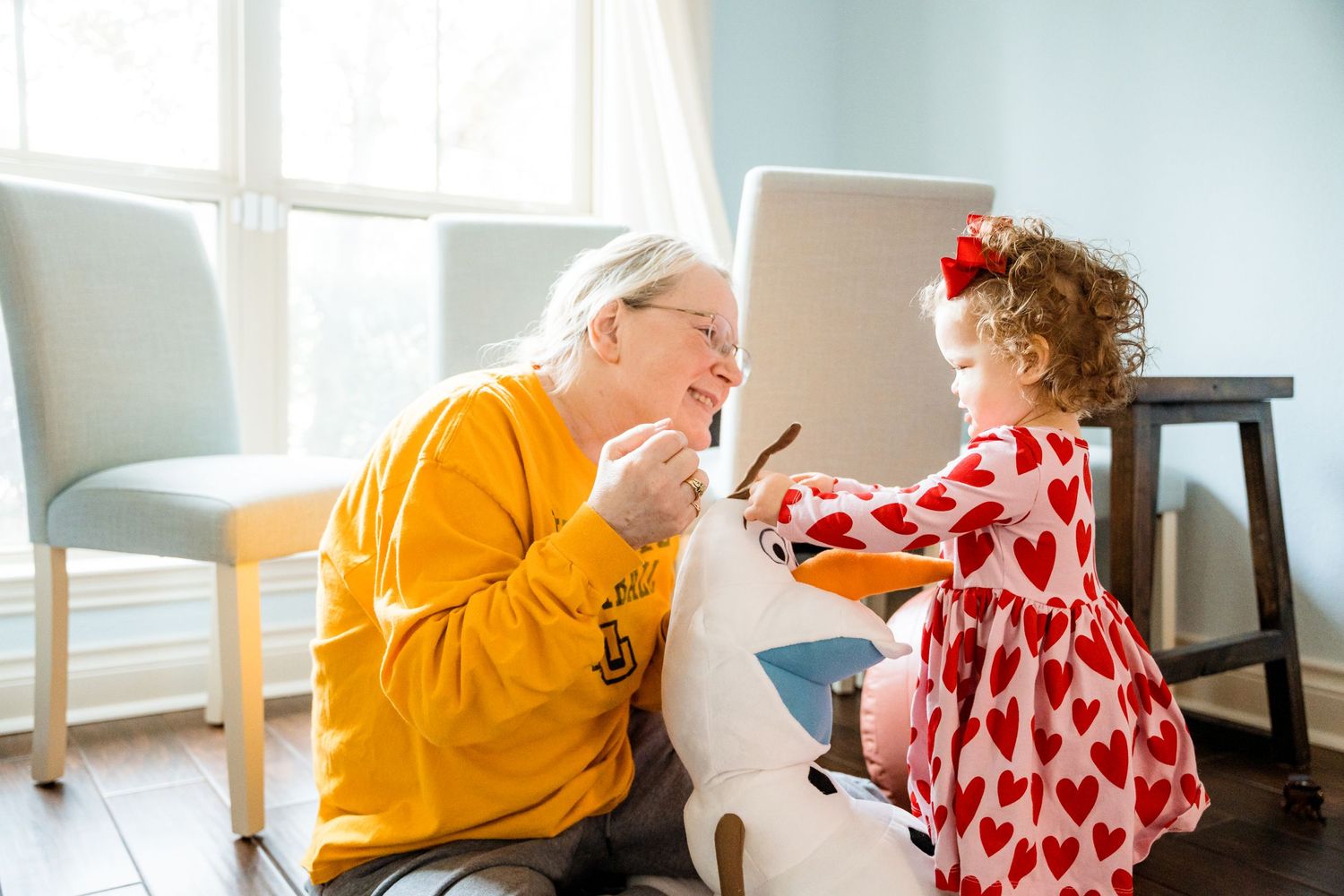 A heartwarming interaction between two people sharing a playful moment in a bright indoor setting.