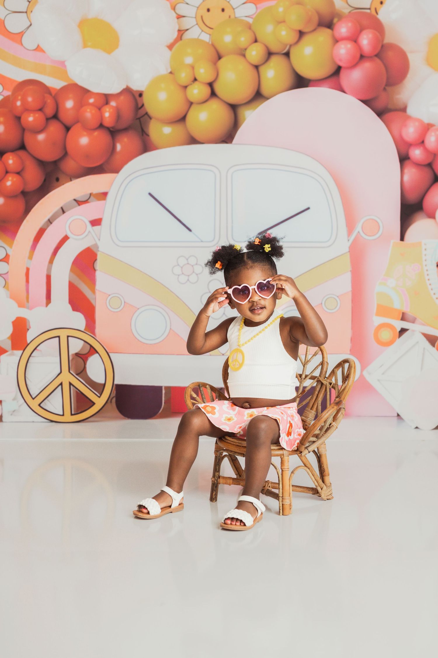 Modern studio photo shoot collage featuring a child model in white against a peachy background with balloon decorations.