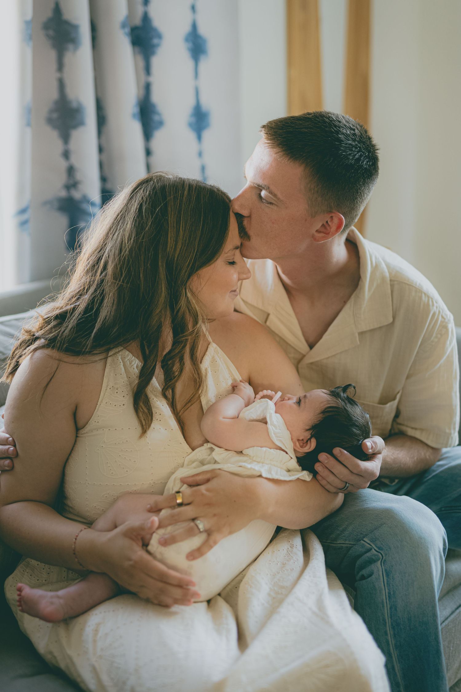 A couple shares tender moments on a couch in a series of romantic lifestyle photos.