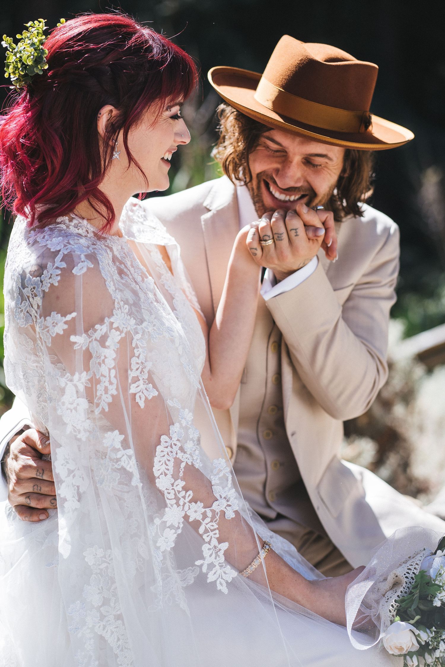 A husband kissing his wife's hand on their wedding day.