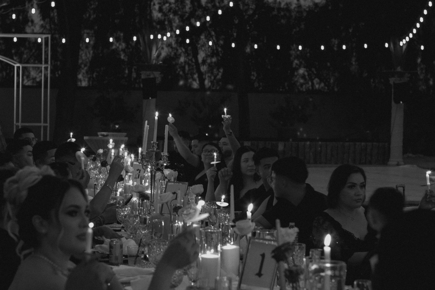 String lights illuminate a dark outdoor venue during a nighttime event or celebration. Tyler Garlej Photography