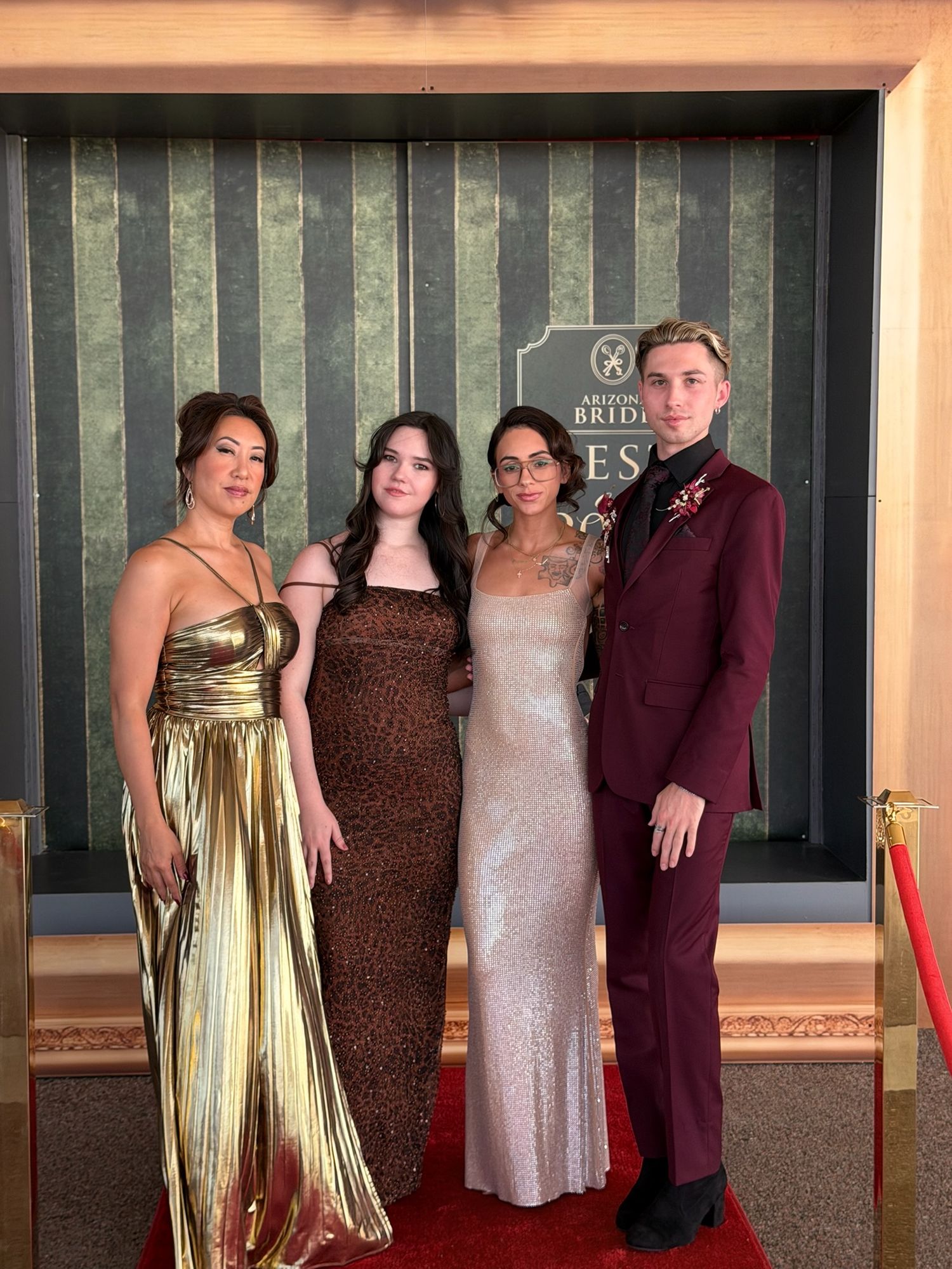 Four elegantly dressed guests posing on a red carpet at an Arizona Bride Best of 2026 formal event.