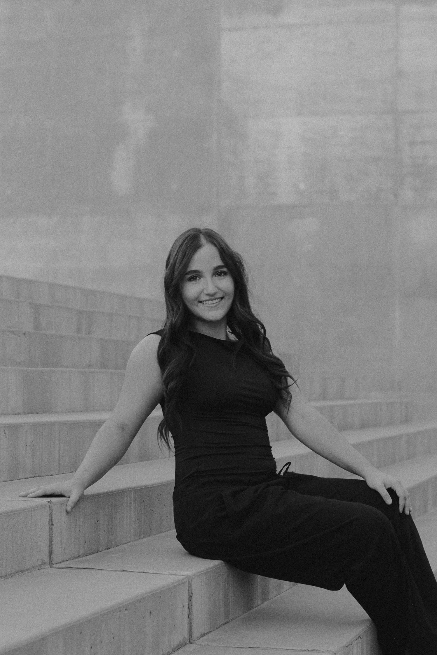 Black and white photo series showing someone in dark clothing posing on outdoor steps in different artistic positions.