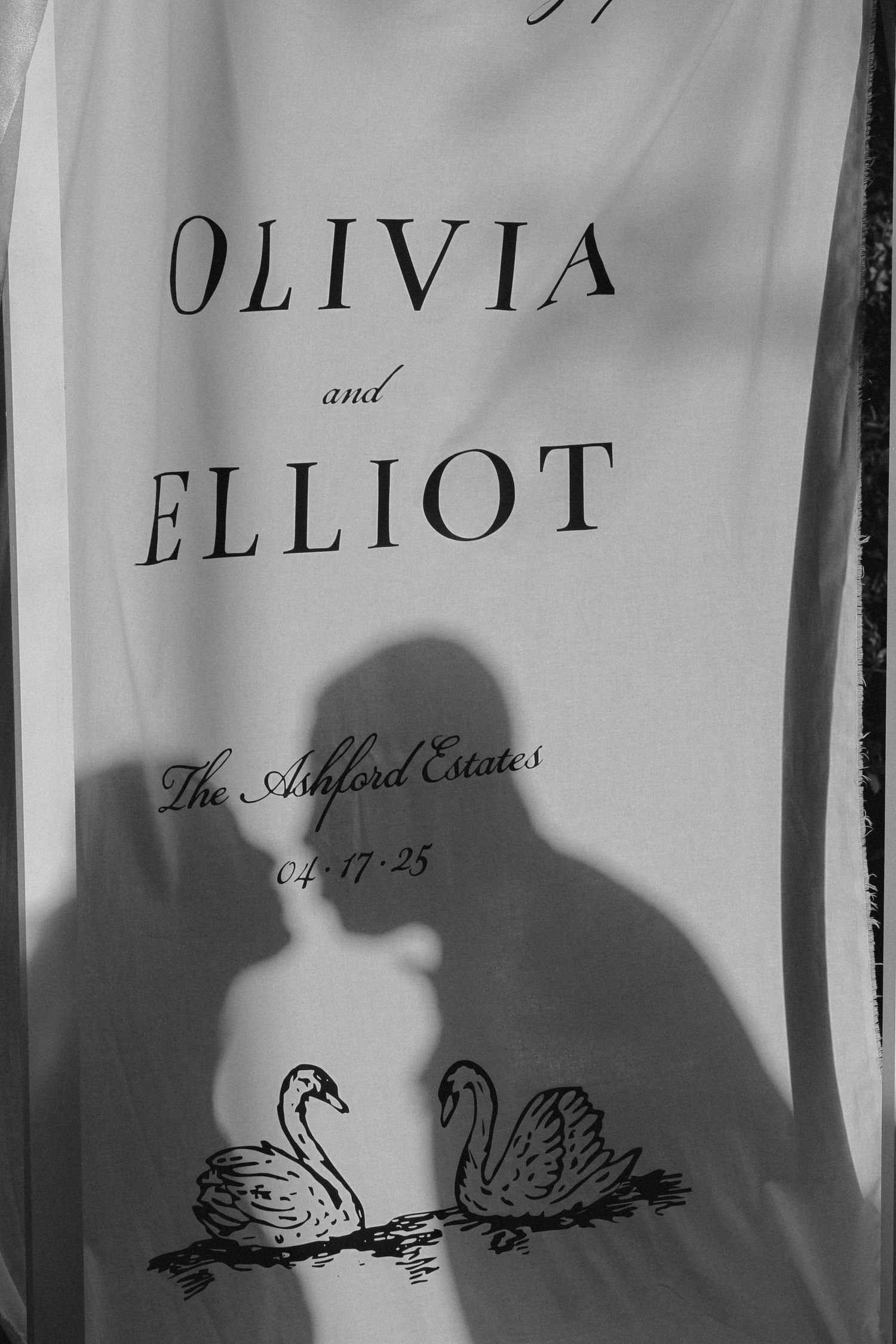 A wedding sign with names Olivia and Elliot featuring decorative swan silhouettes and the property name Shefford Estates.