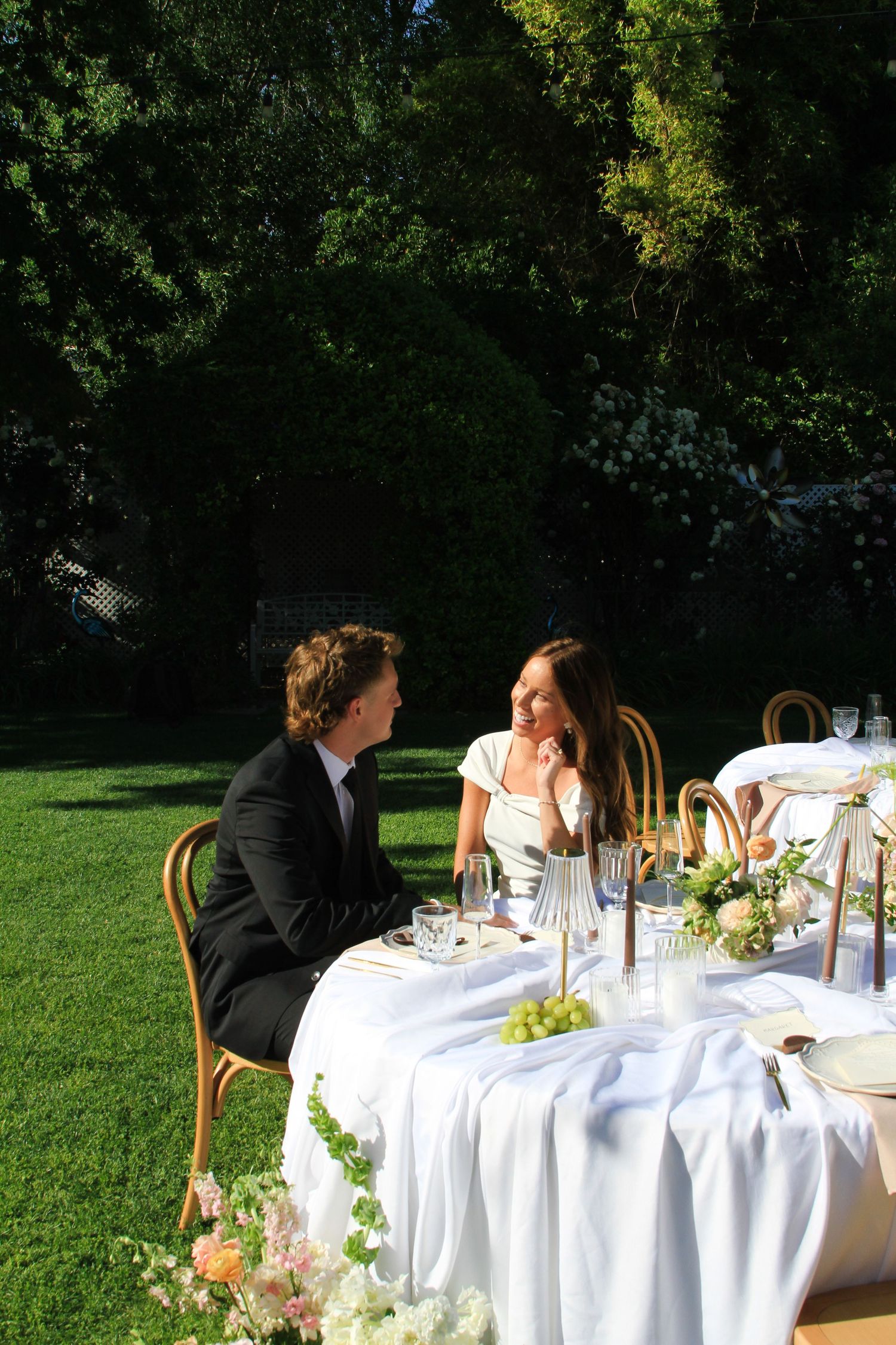 A couple shares an intimate moment at their outdoor garden wedding reception.