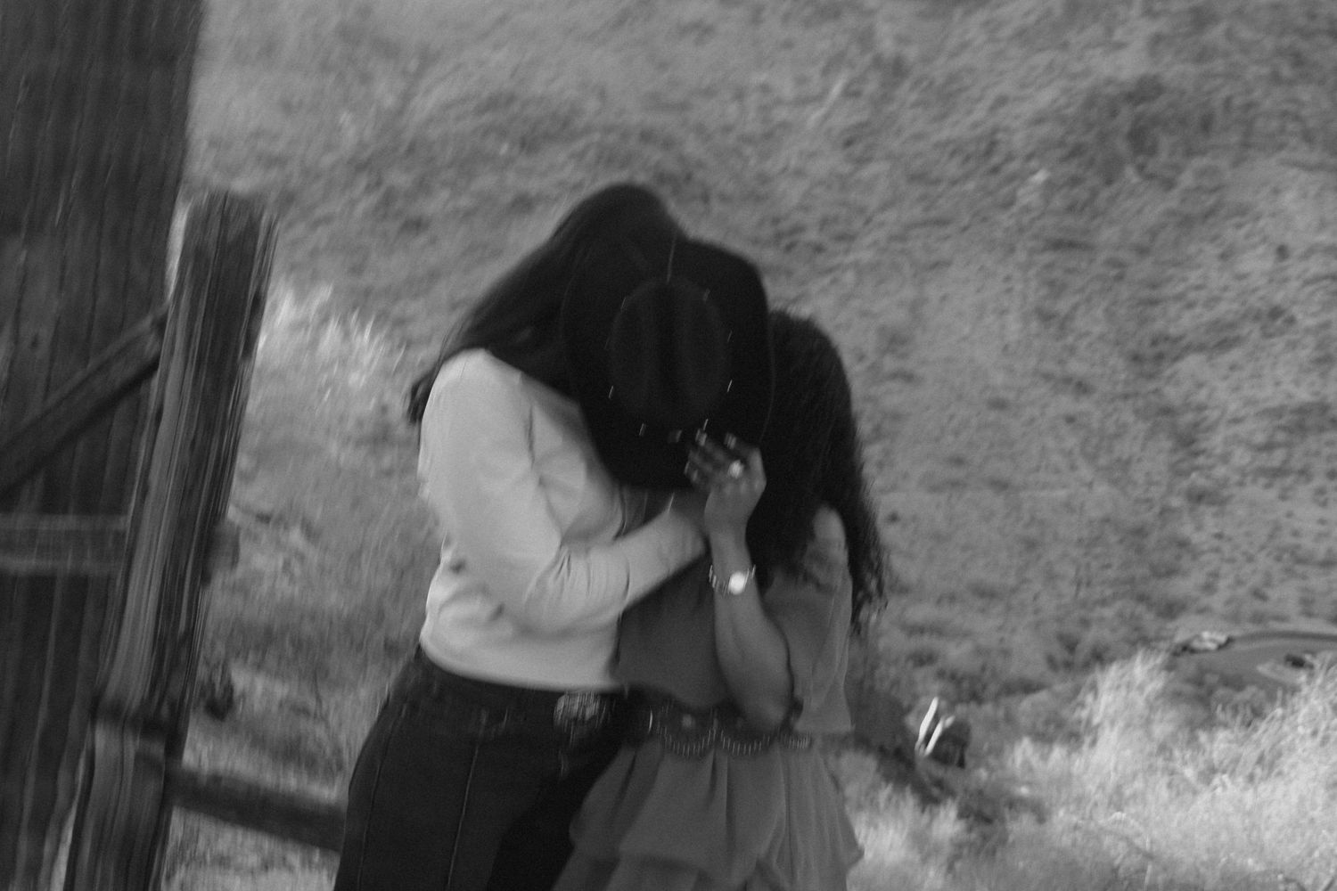 Black and white photo of two people embracing outdoors.