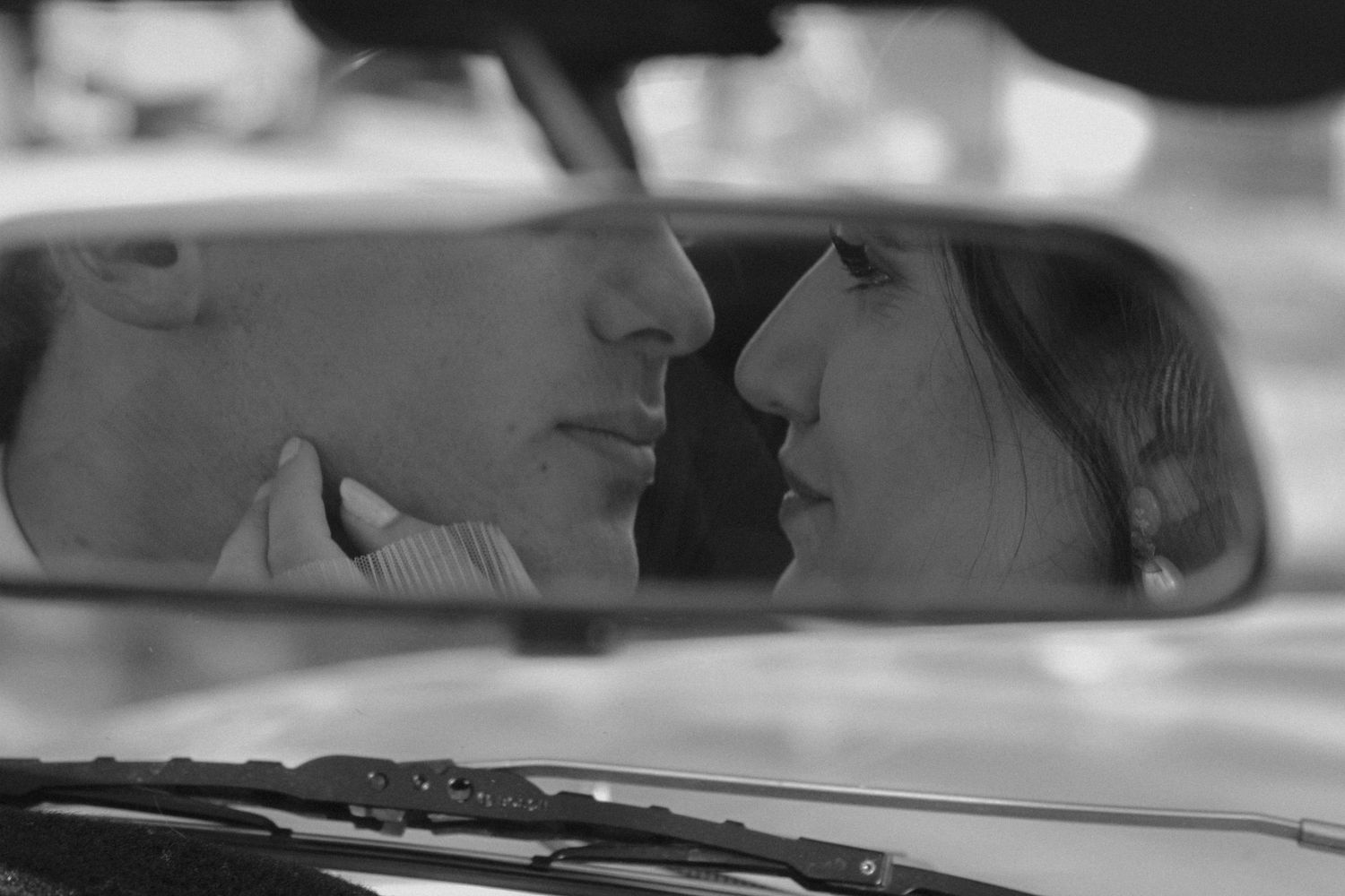 Black and white film strip showing cropped portions of a car and people in what appears to be a vintage movie scene. Tyler Garlej Photograph