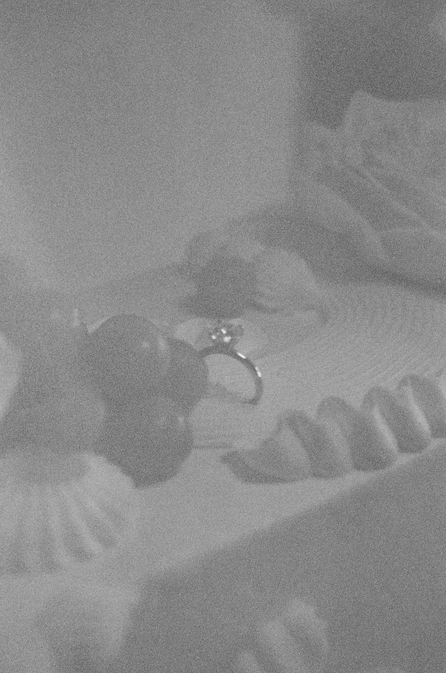 Tyler Garlej Photography - A black and white image shows a close-up view of piano keys in dim lighting.