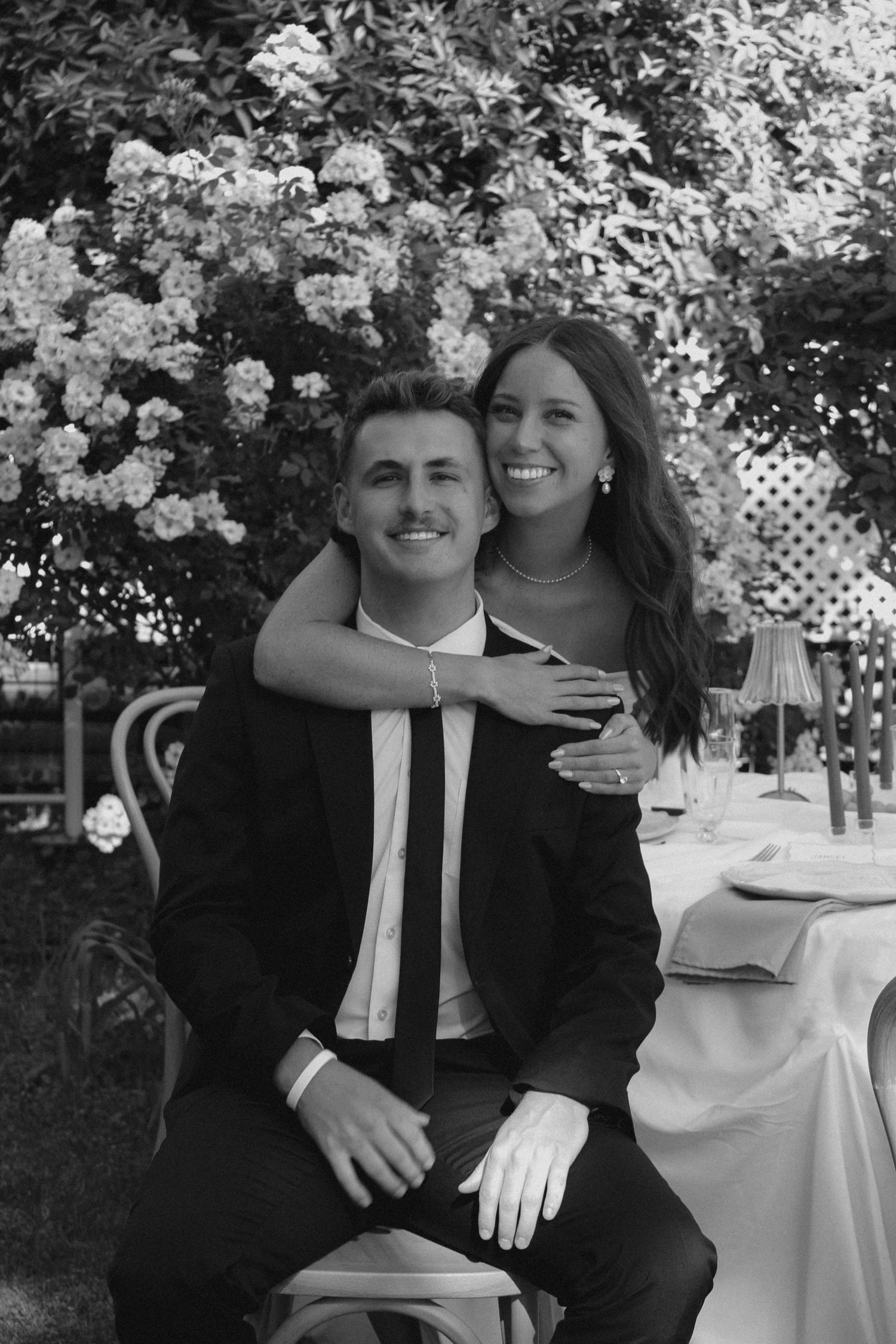 Black and white portrait of a happy couple at their garden wedding reception.