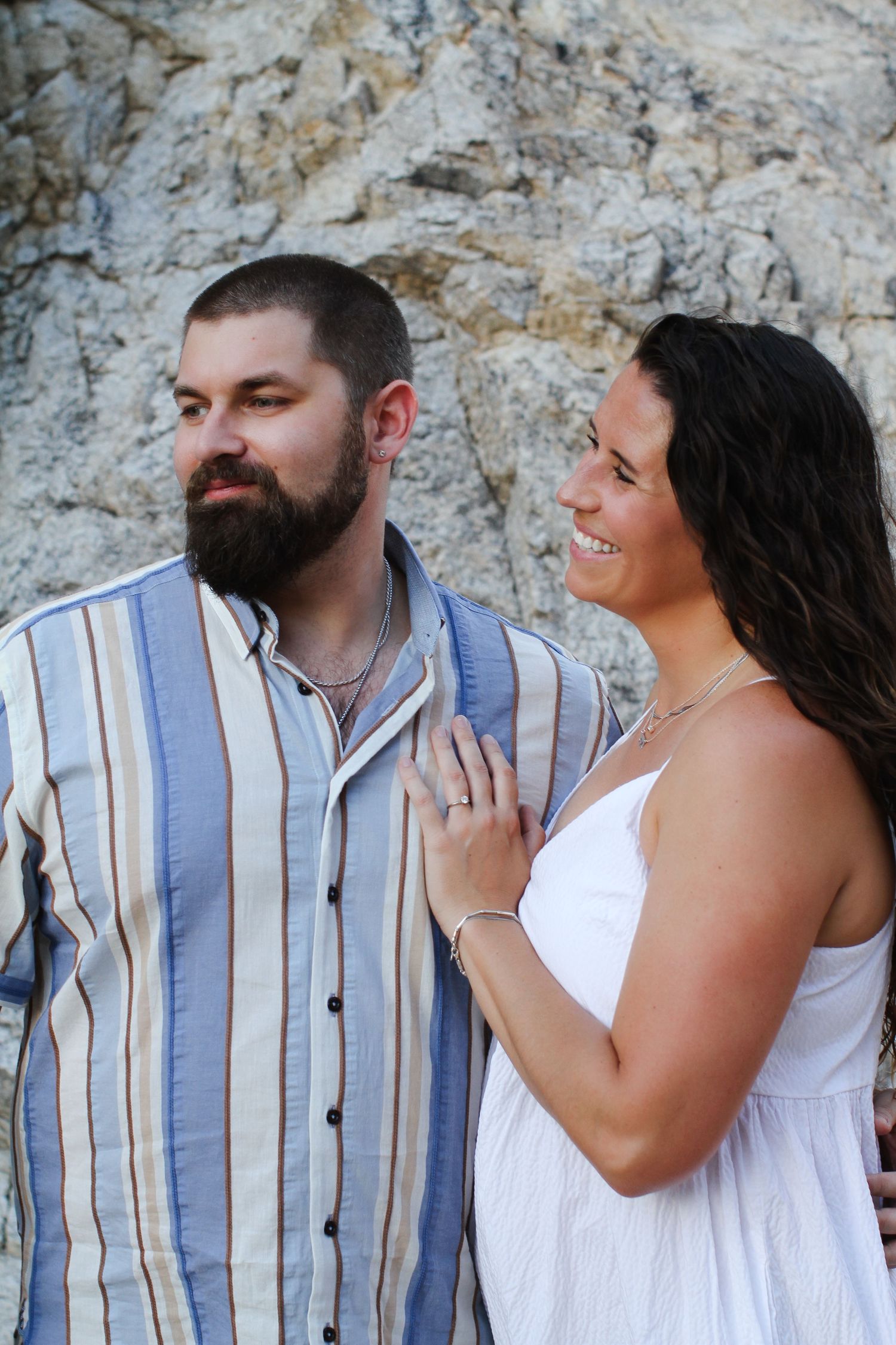 Candid moments captured between a couple against a rocky outdoor setting.