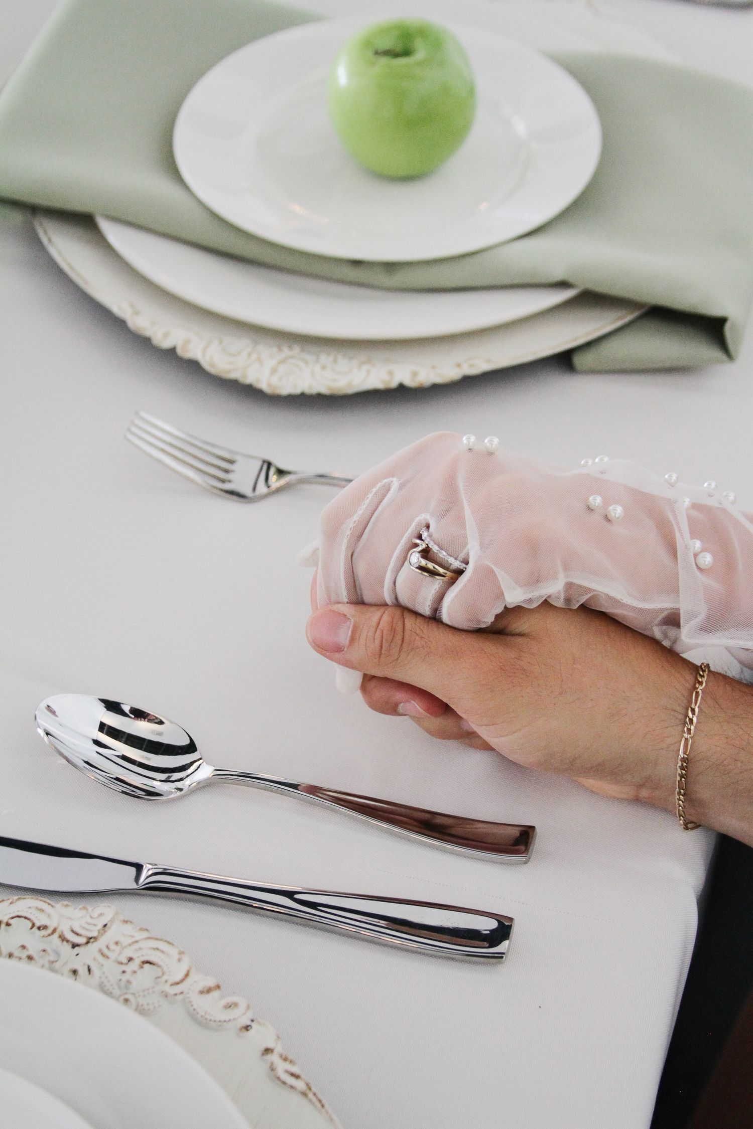 Tyler Garlej Photography - A hand wearing a white lace glove demonstrates proper table etiquette with silverware on a white tablecloth.
