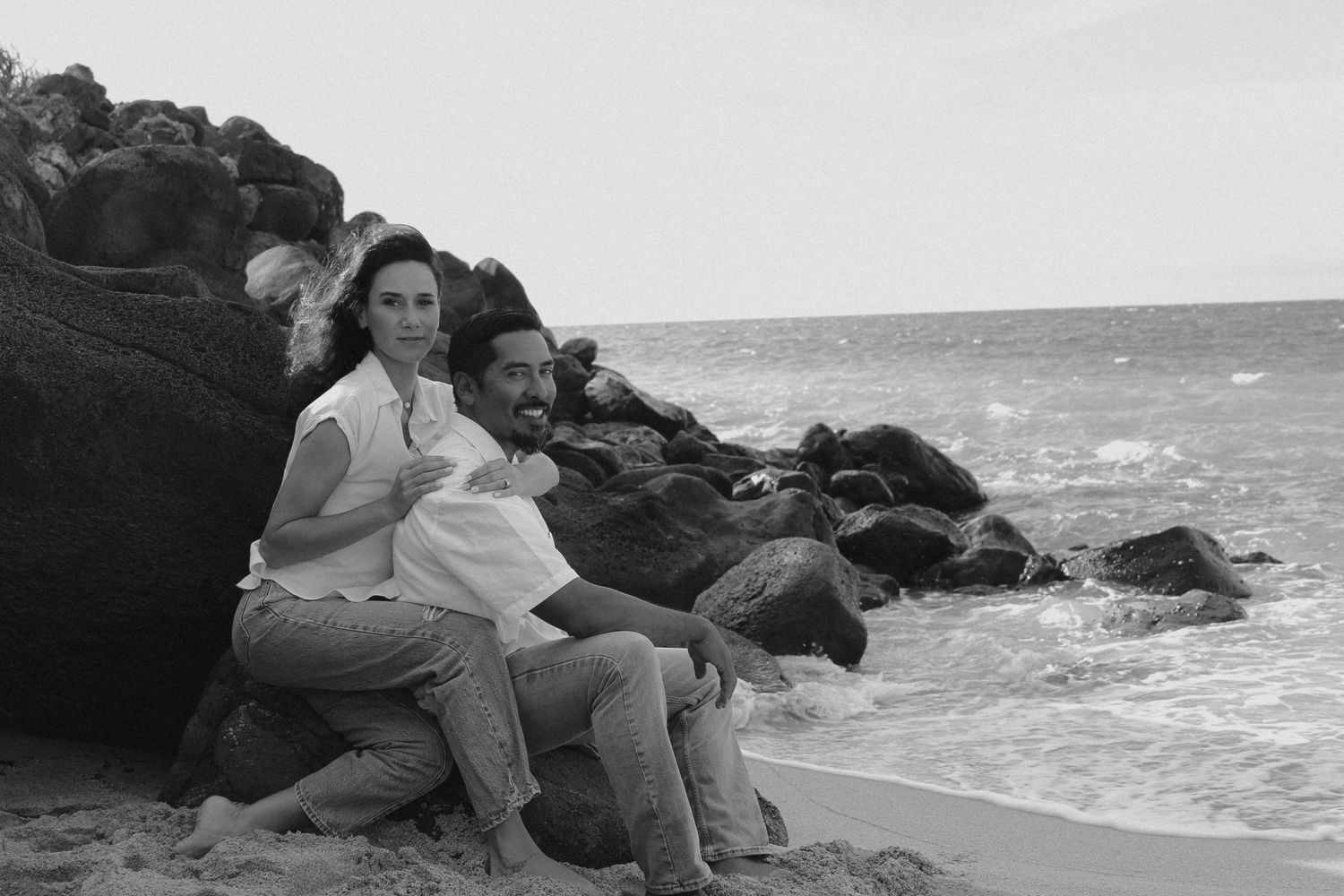 Tyler Garlej Photography - A black and white photo series shows people sitting on rocky cliffs by the ocean.