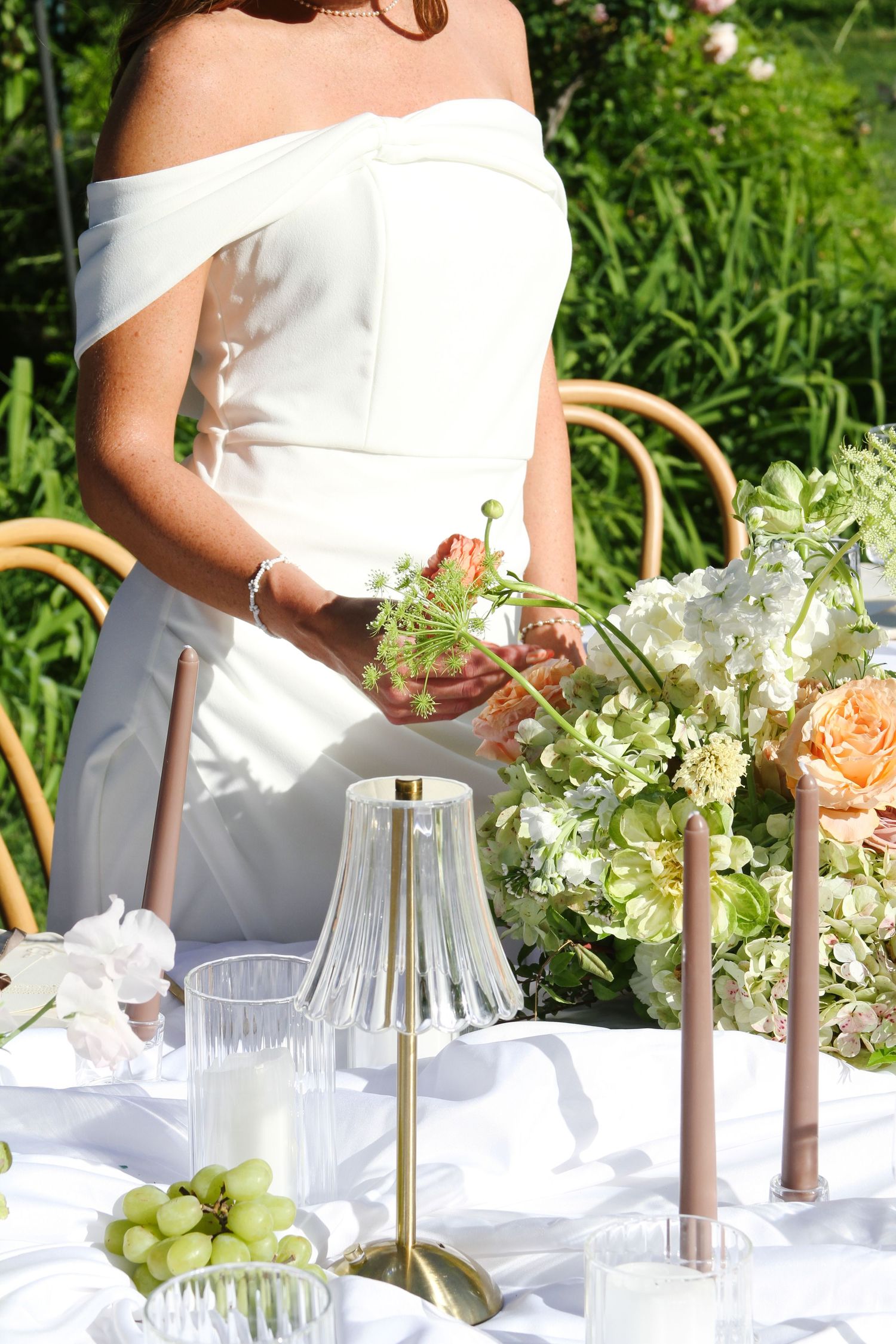 An elegant garden wedding reception table setting with fresh flowers and white linens.
