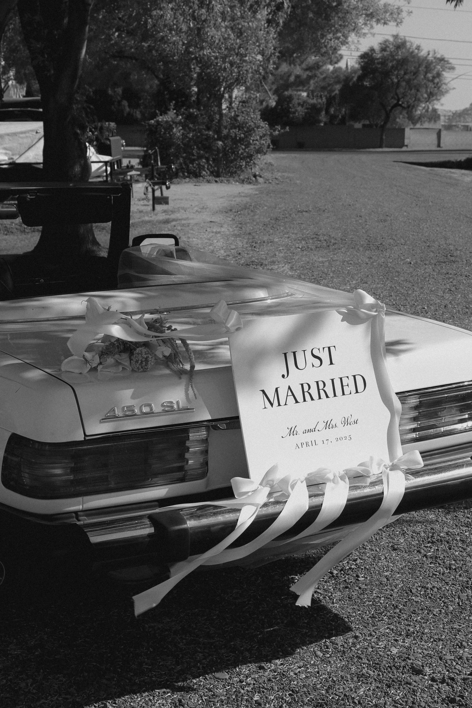 Classic cars decorated with 'Just Married' signs and ribbons parked in black and white vintage style. Tyler Garlej Photography