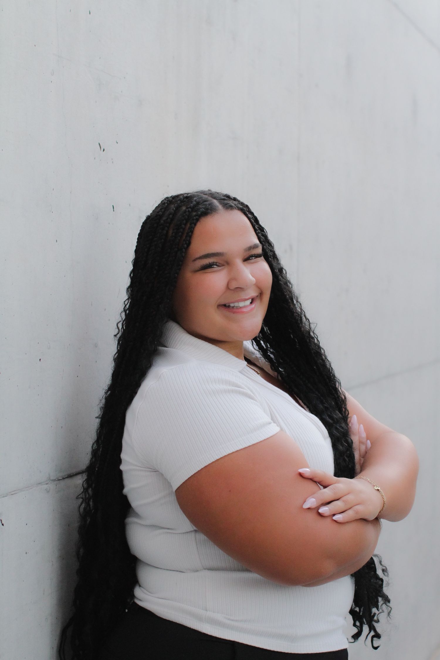 A figure in a white top poses against a light colored wall in a series of candid shots.