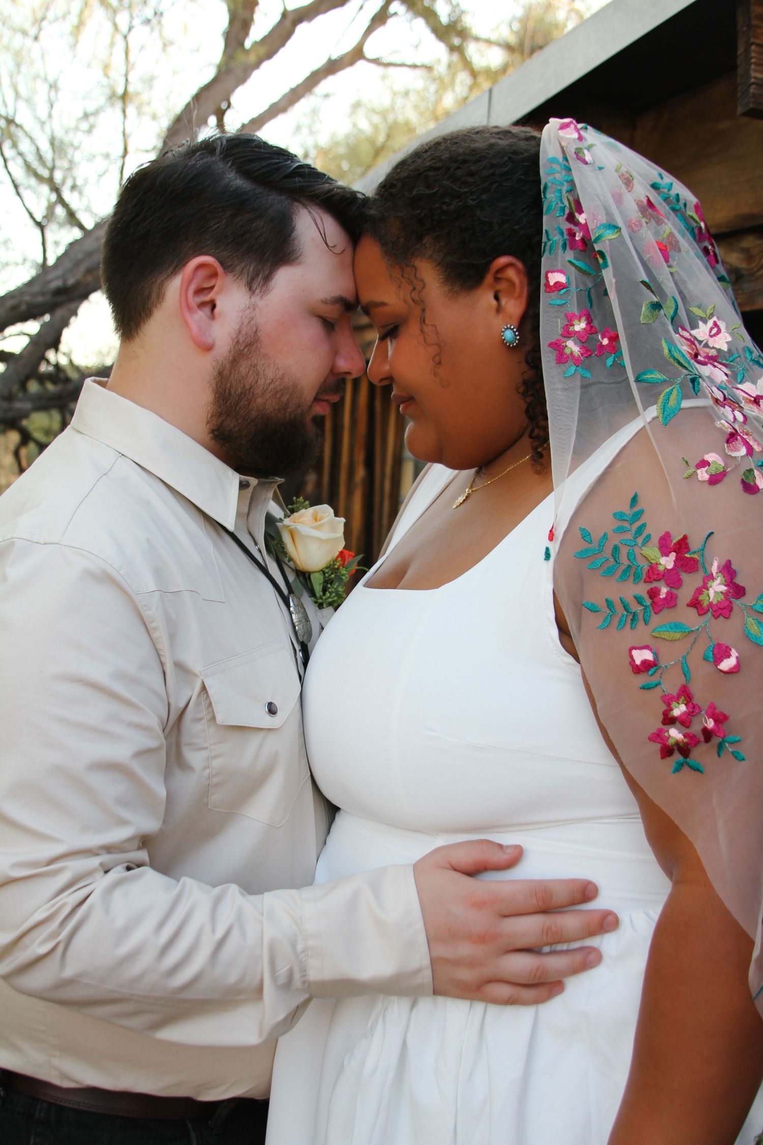 Intimate couple's portrait showing tender embrace during outdoor photoshoot.