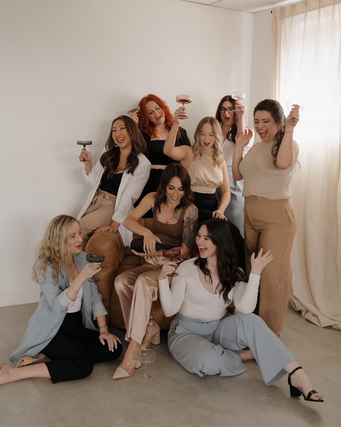 Group of friends laughing and posing together in a bright studio interior.