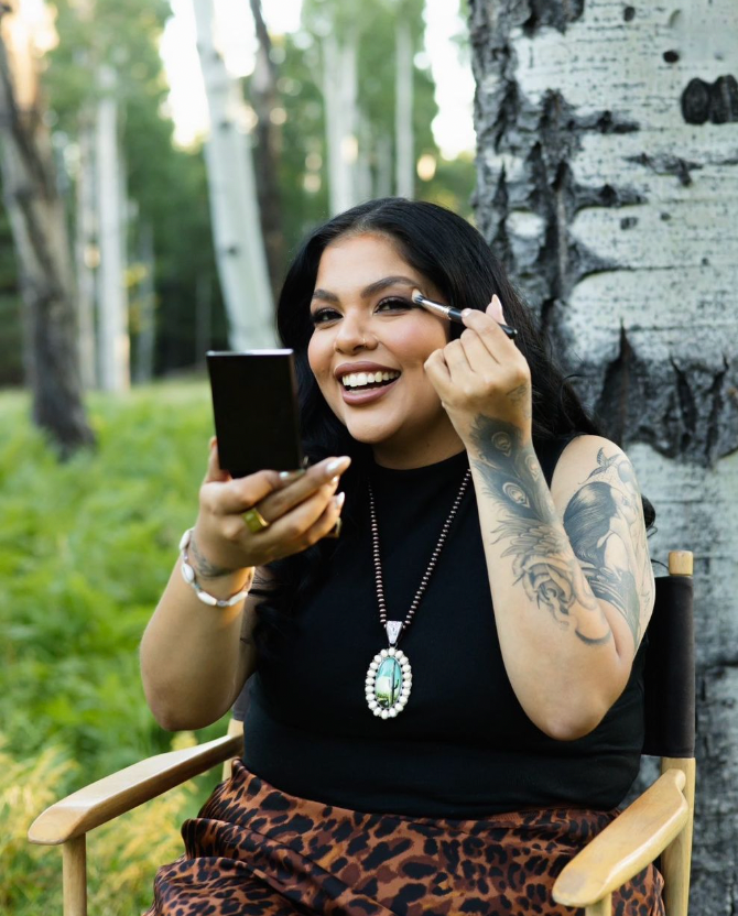 Outdoor beauty session near birch trees showing makeup application and styling details.