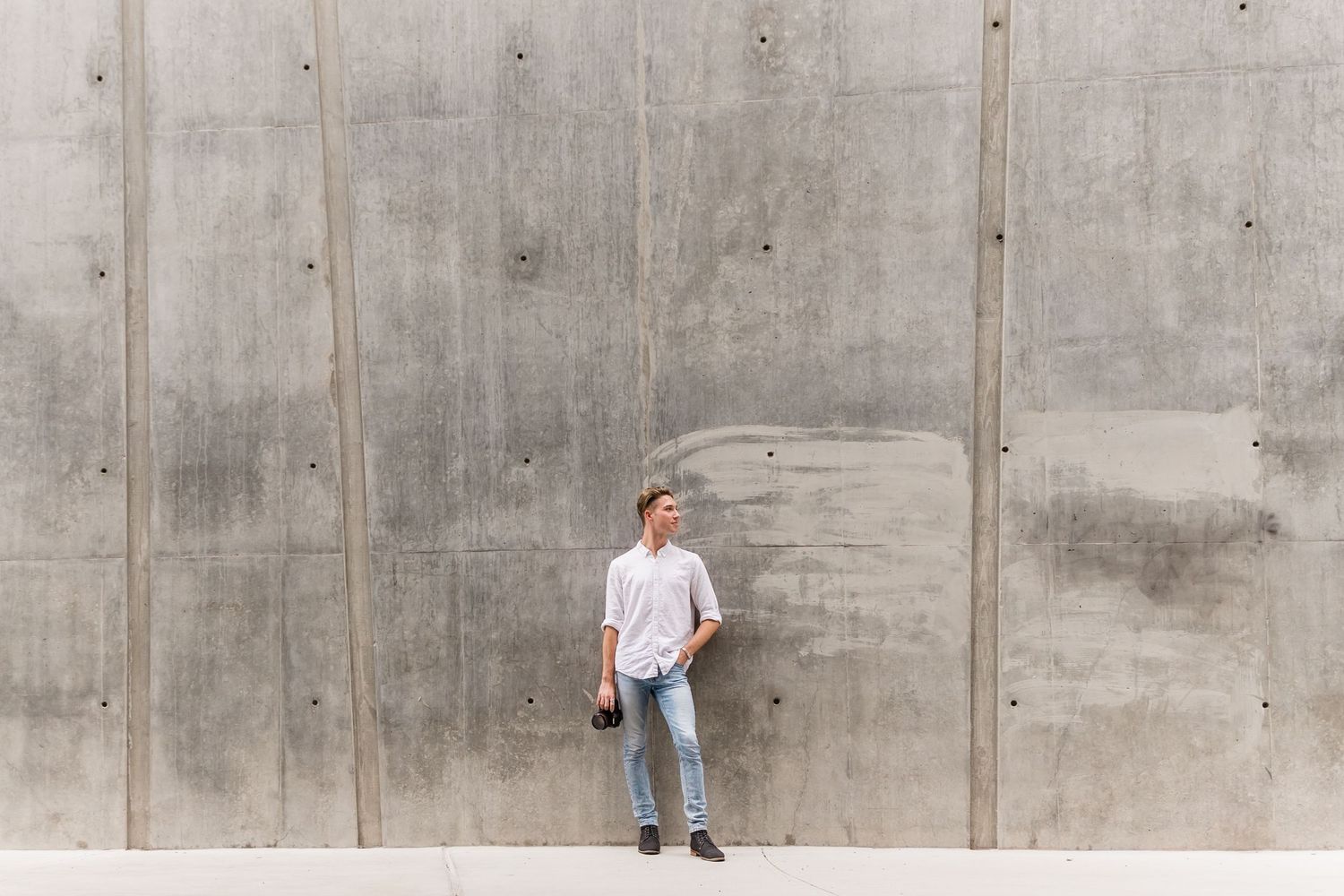 Modern casual lifestyle photo against industrial concrete wall background.