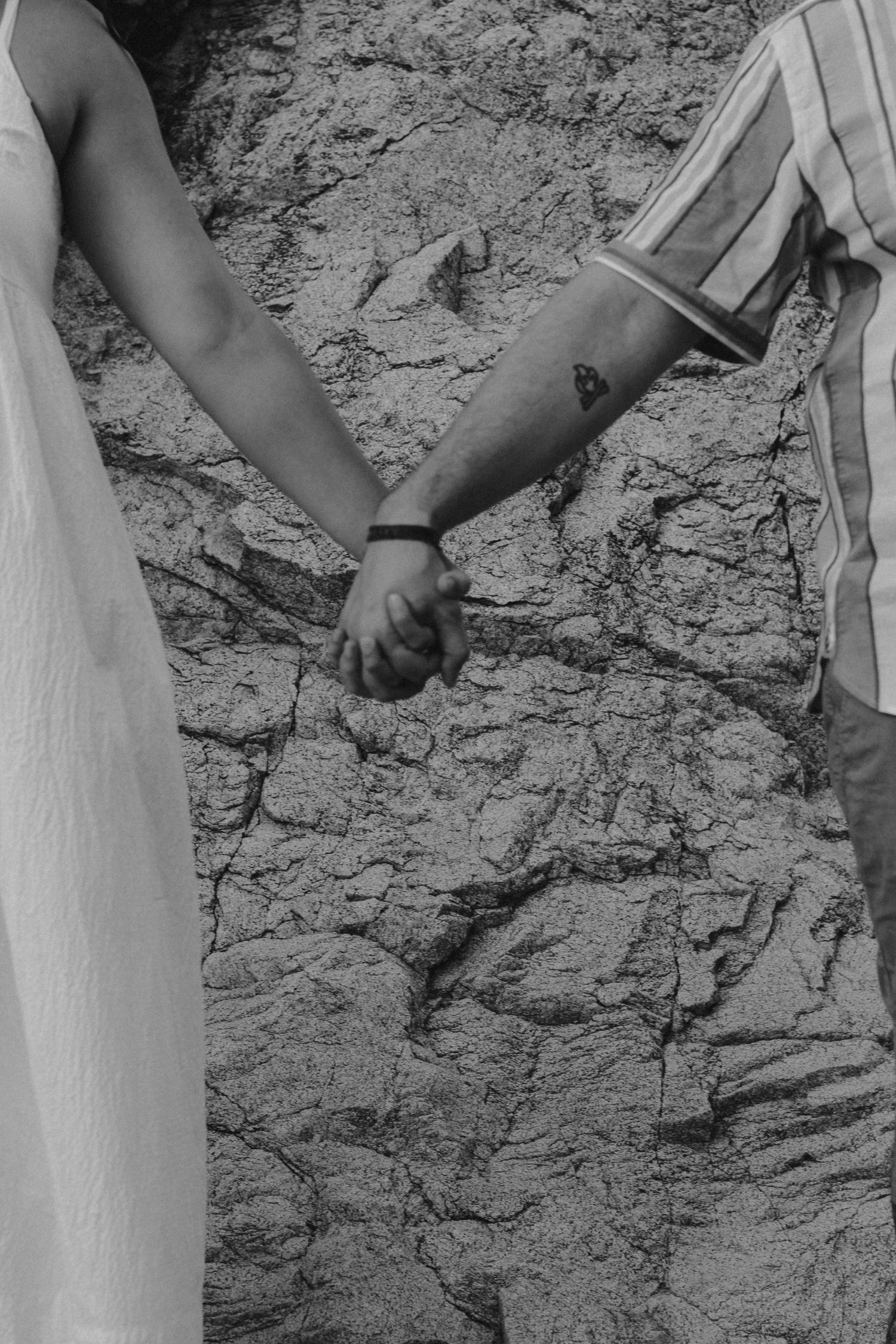 Detail shot of legs and clothing against a textured stone wall backdrop.