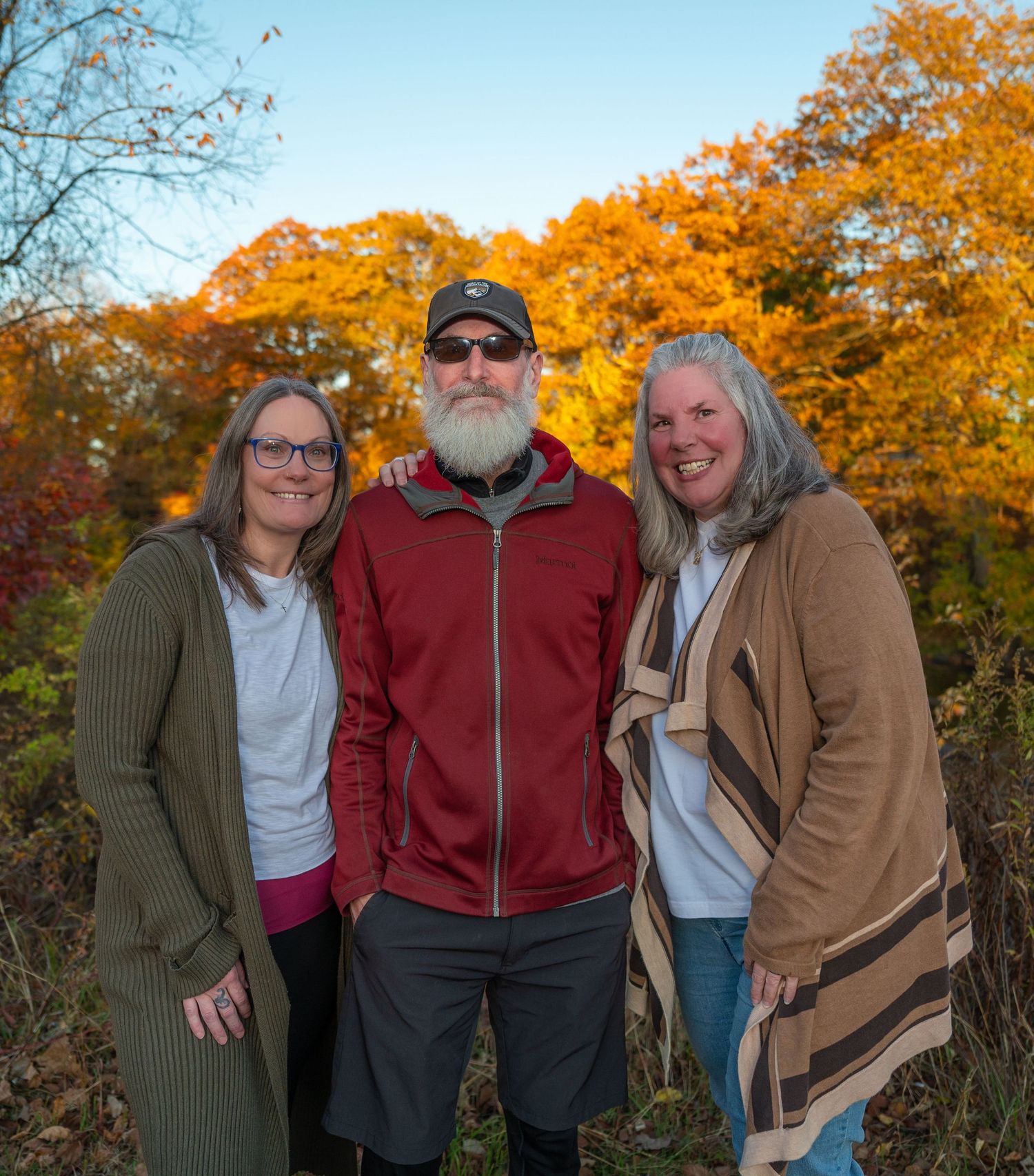 3 siblings posing for a family portrait with true to color photography.