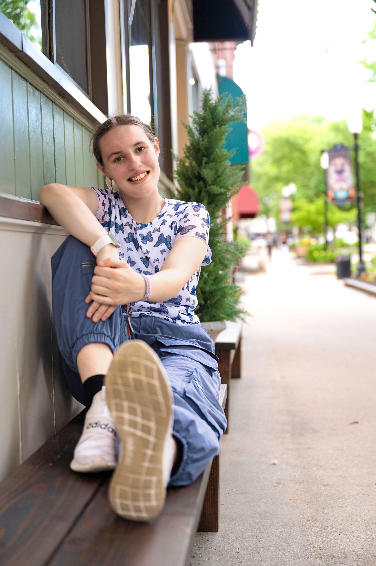 A girl sitting on a bench posing for a natural color photo in downtown Keene, New Hampshire