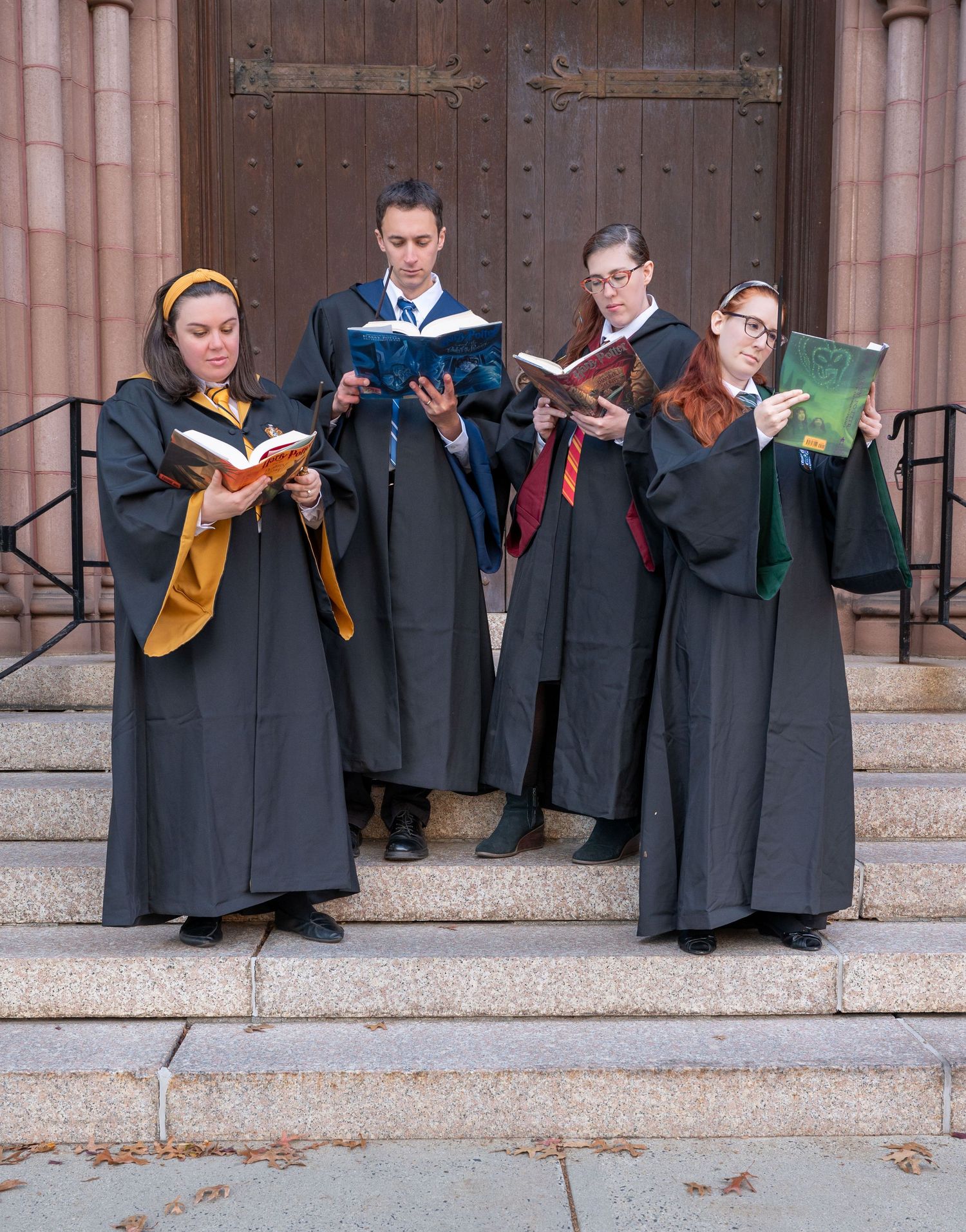 A group of friends dressed as Hogwarts students reading Harry Potter books at Mt. Holyoke College.