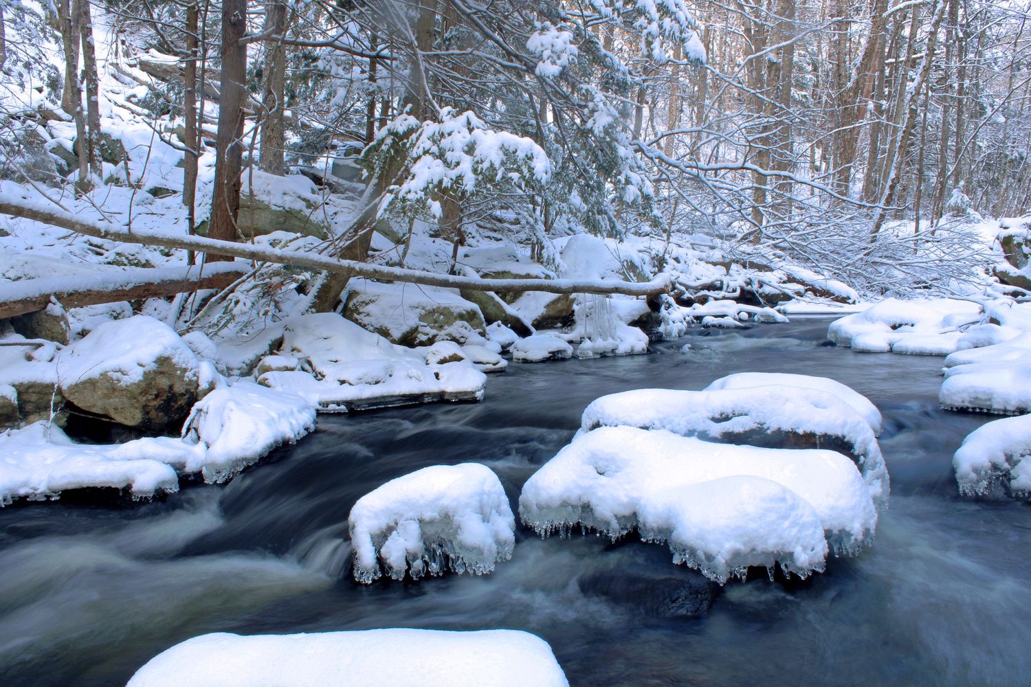 A running river covered with fresh snow