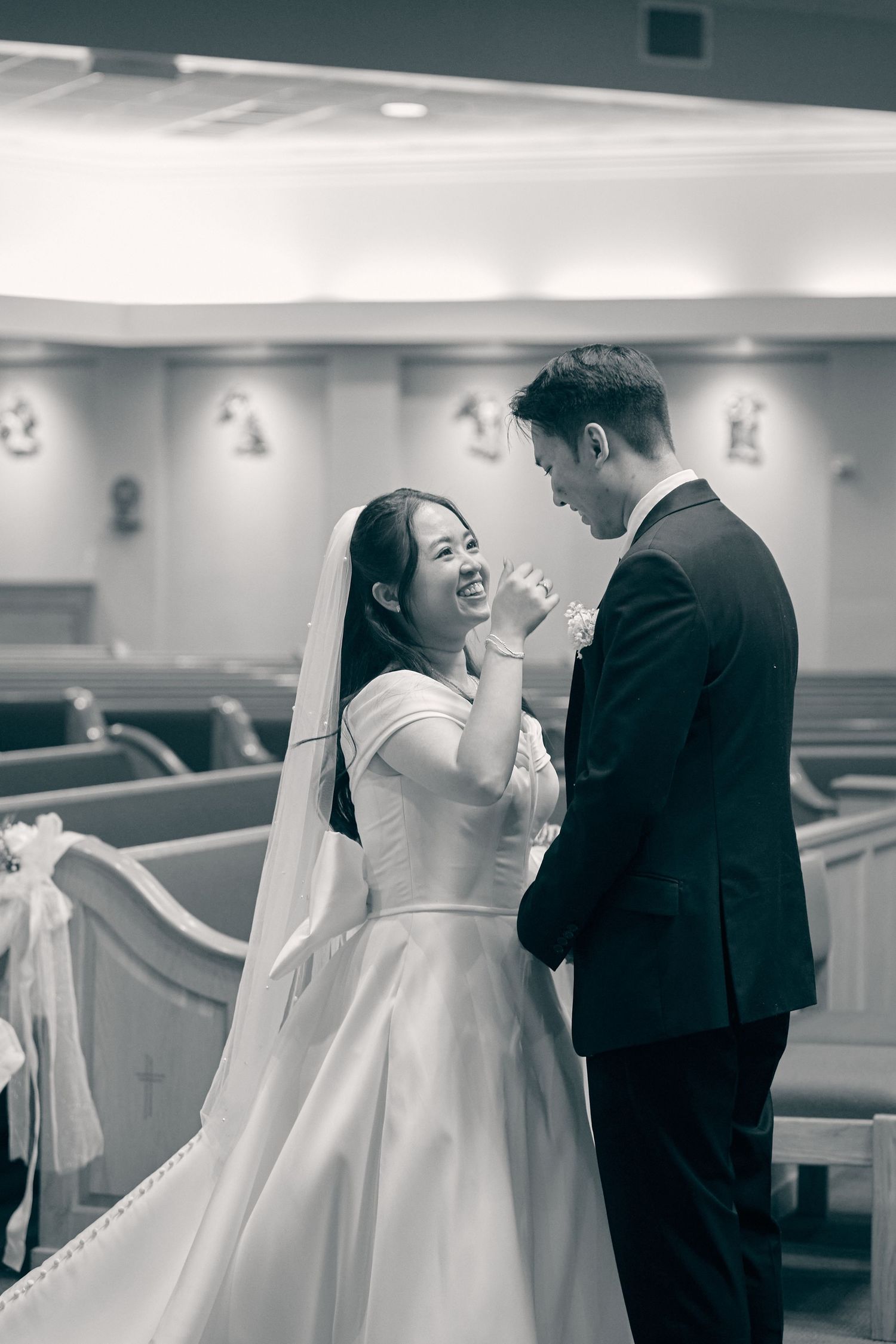 Joyful bride and groom sharing a tender moment inside a church during their wedding ceremony.