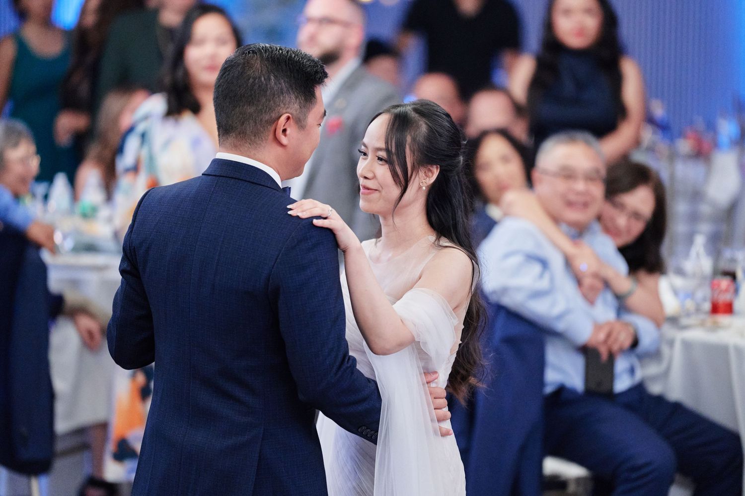 Bride and groom sharing tender first dance moment at elegant wedding reception.
