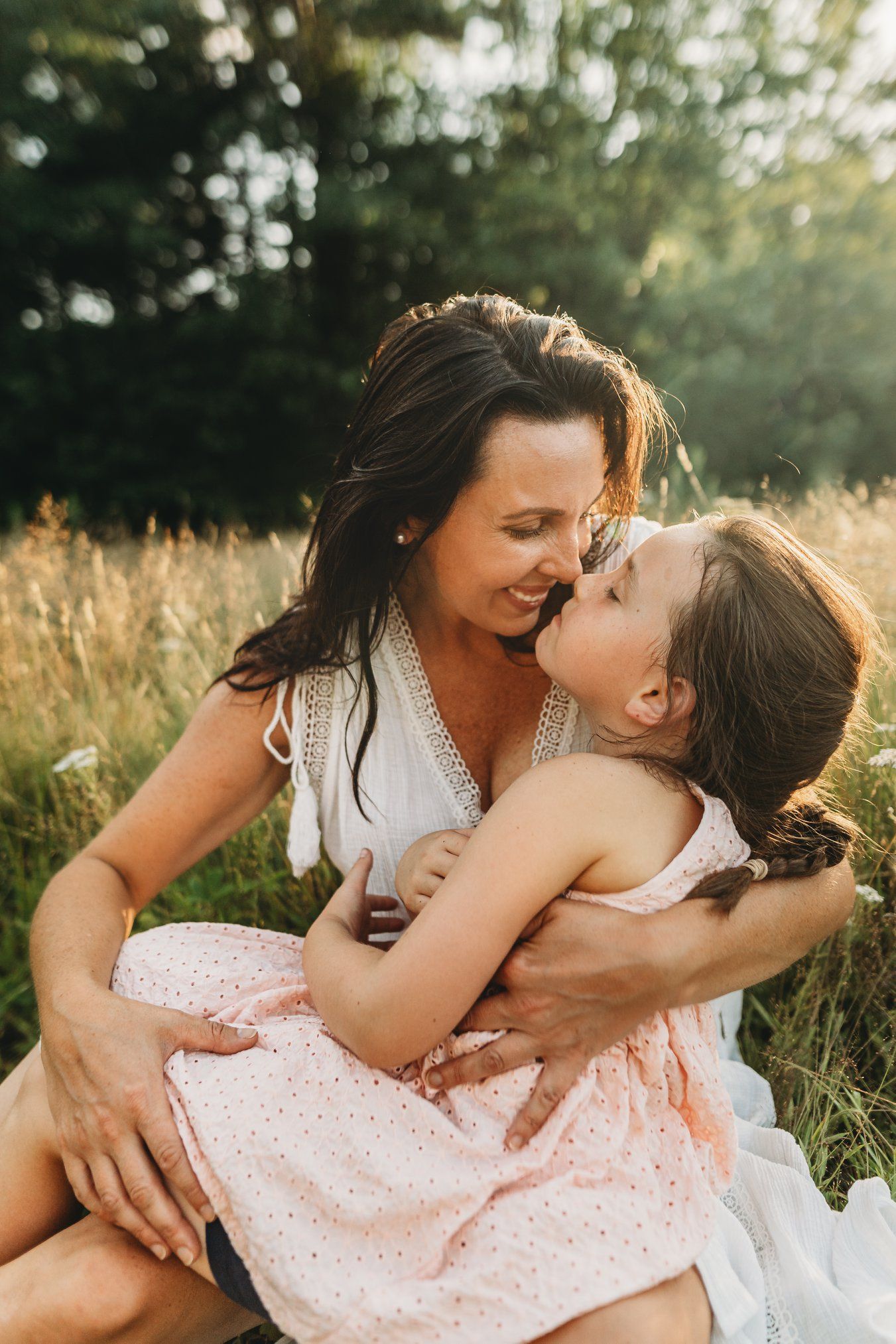 Motherhood photography in Littleton, New Hampshire capturing a mother and daughter embracing in golden hour light.