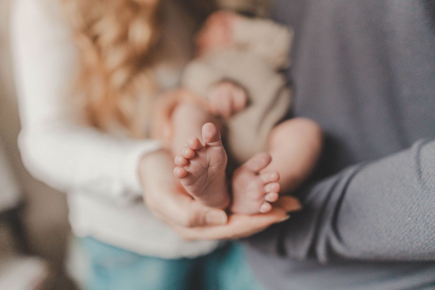 In-home newborn photography in Littleton, NH featuring close-up details of baby’s hands and facial features.