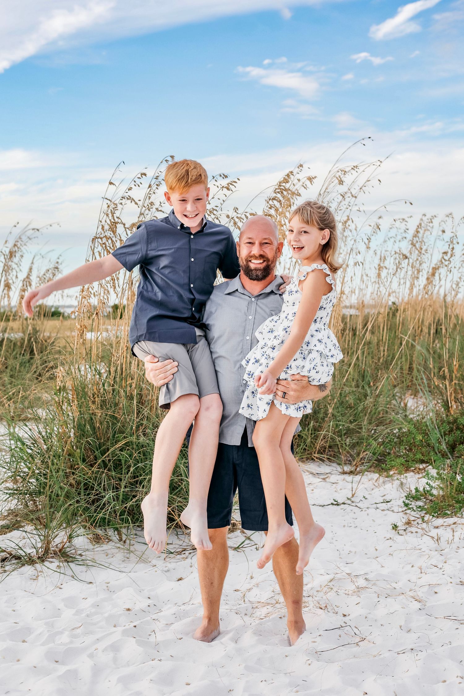 A playful sequence of people dancing and jumping together on a white sandy beach with sea oats in the background.