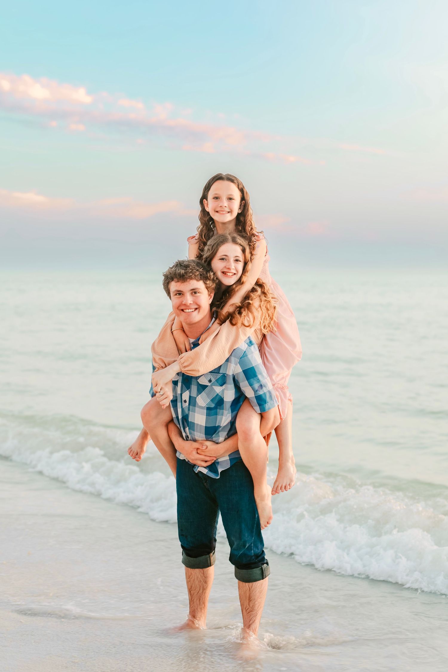Playful piggyback rides on the beach during sunset family photoshoot.