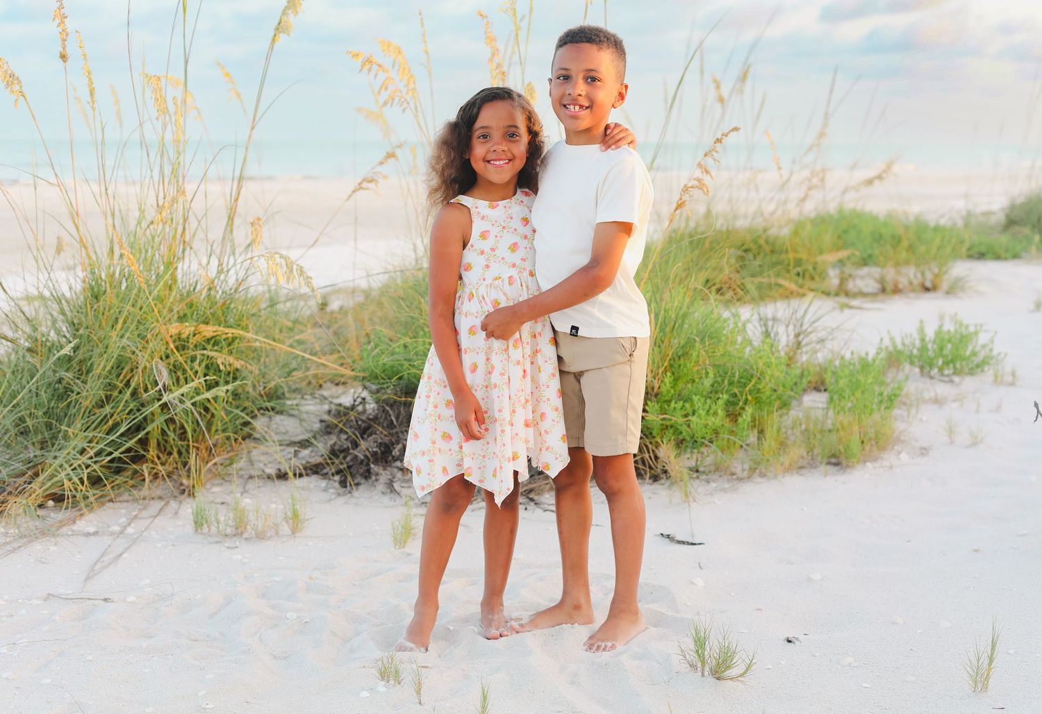 Candid beach photos of family members standing together near coastal dune grass.