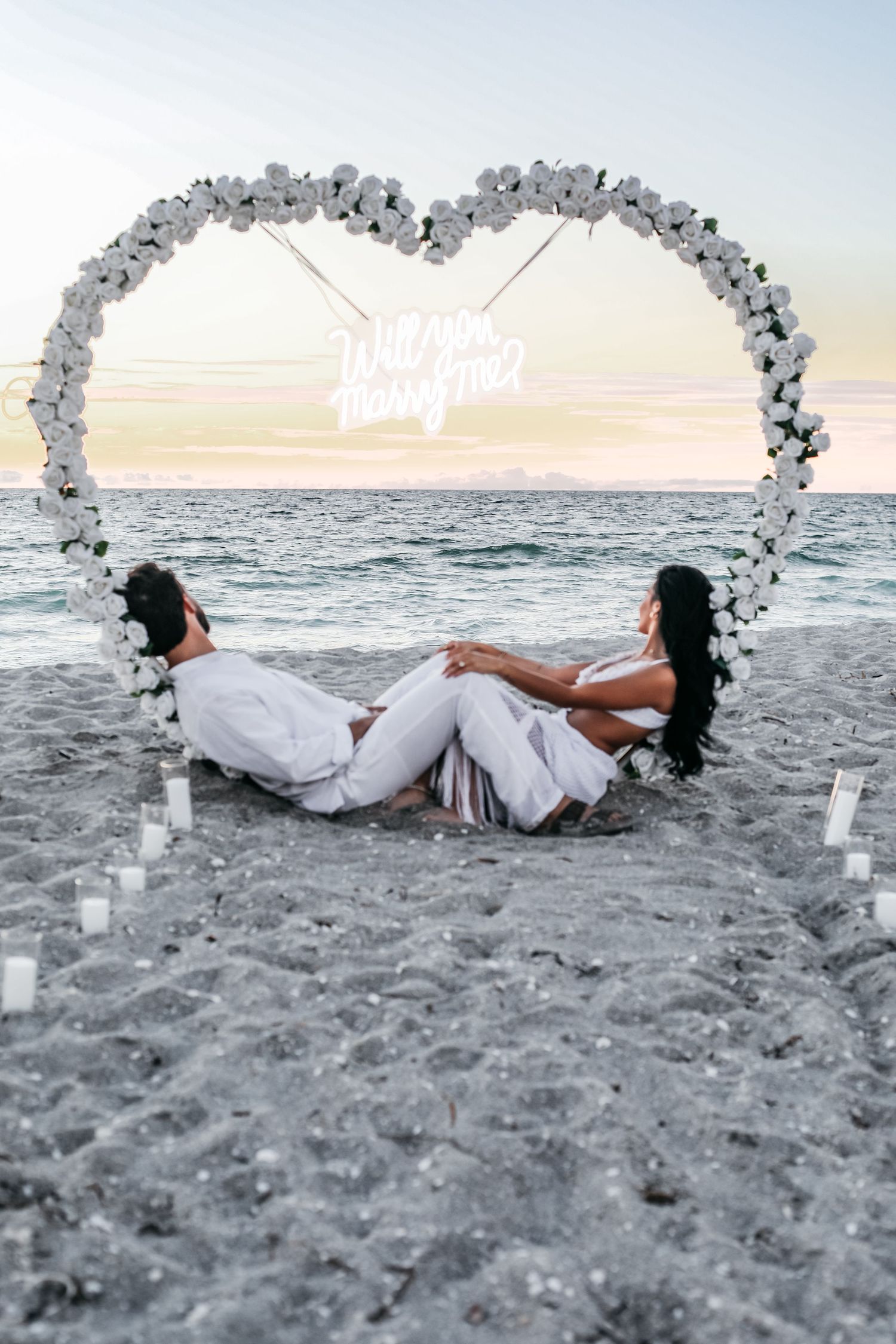 A series of artistic beach photos showing a person in white dress laying on sandy shore at sunset.
