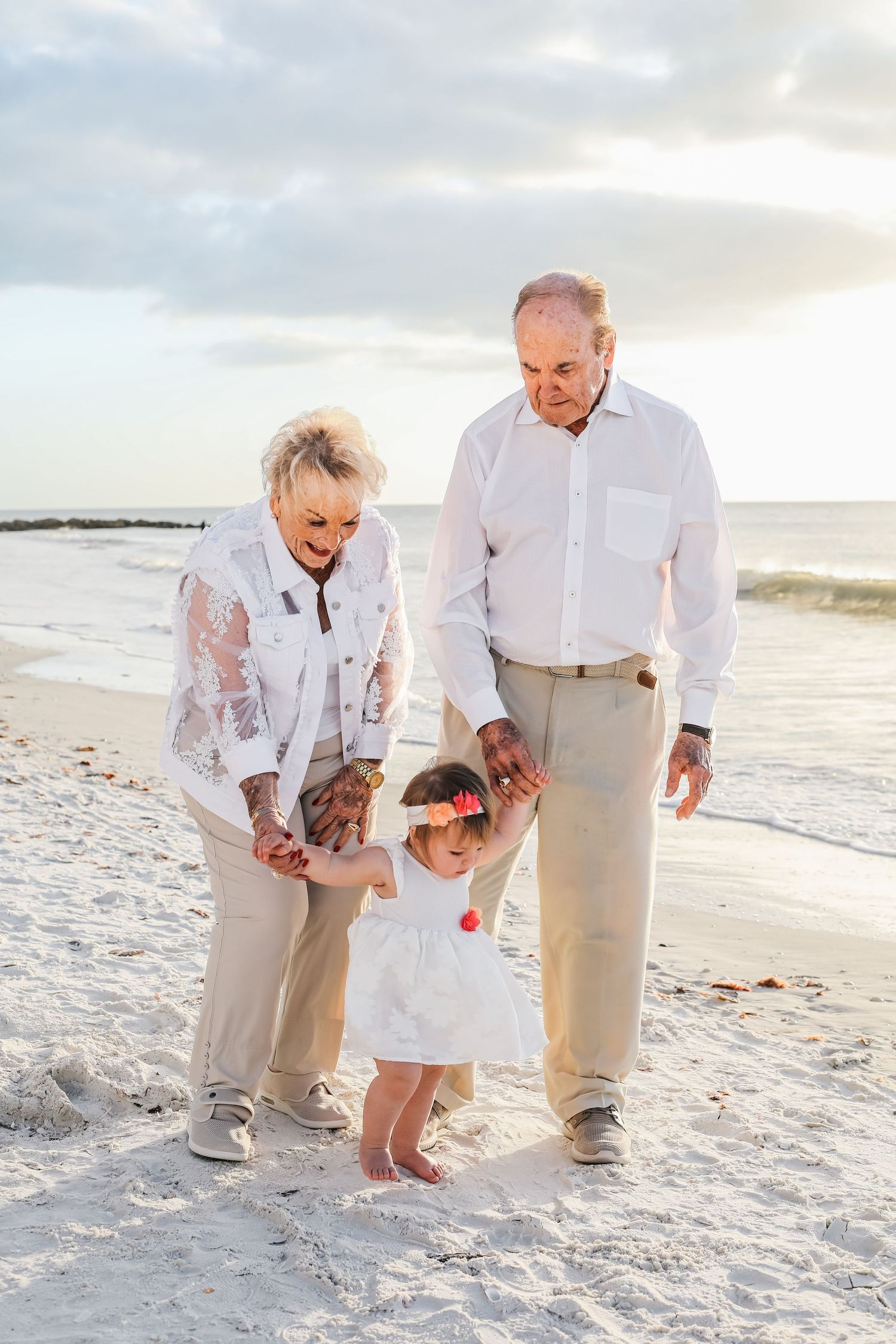 A series of candid photos showing people walking together on a white sandy beach at sunset.