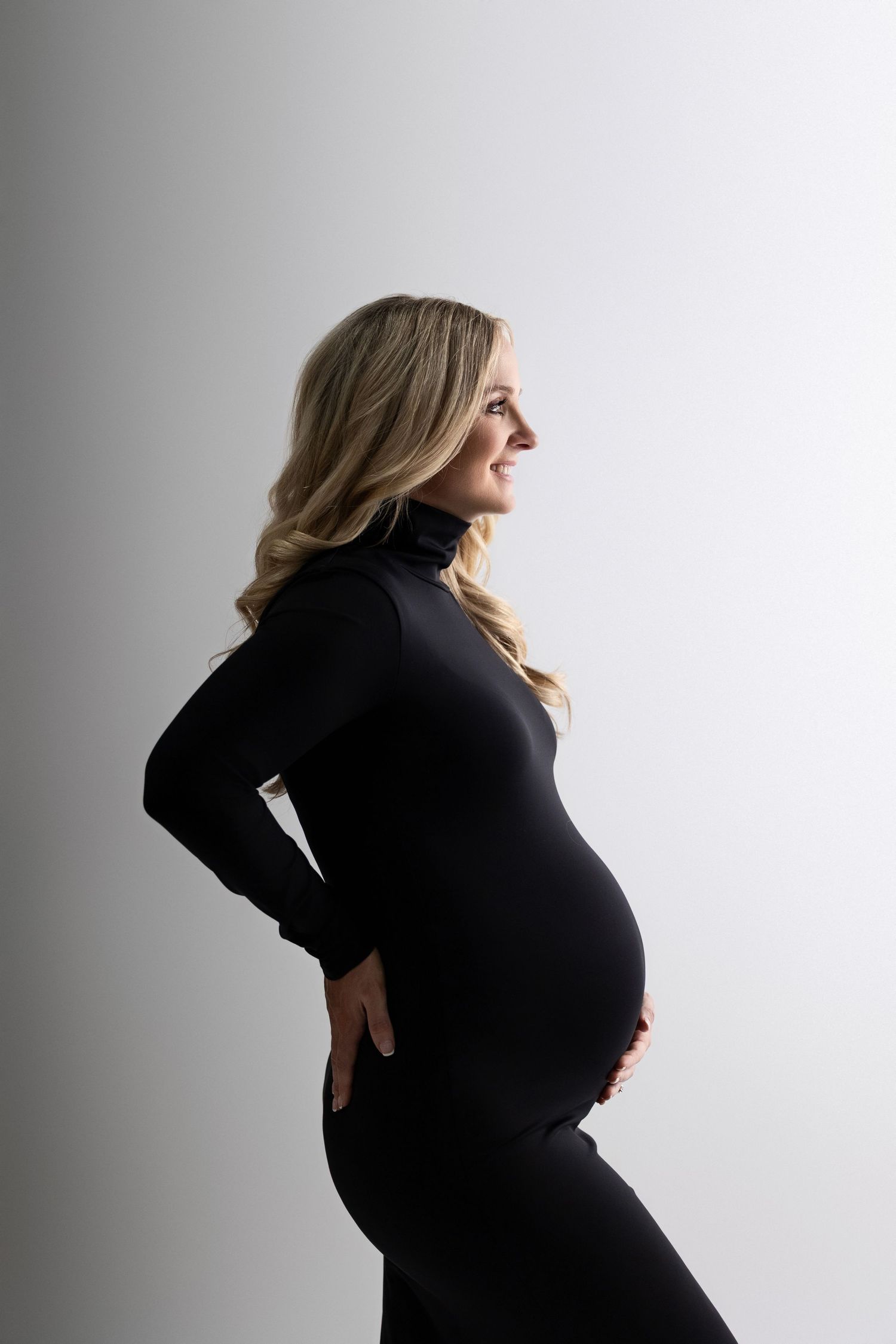 A silhouetted figure in black clothing poses against a white backdrop in a series of artistic profile shots.