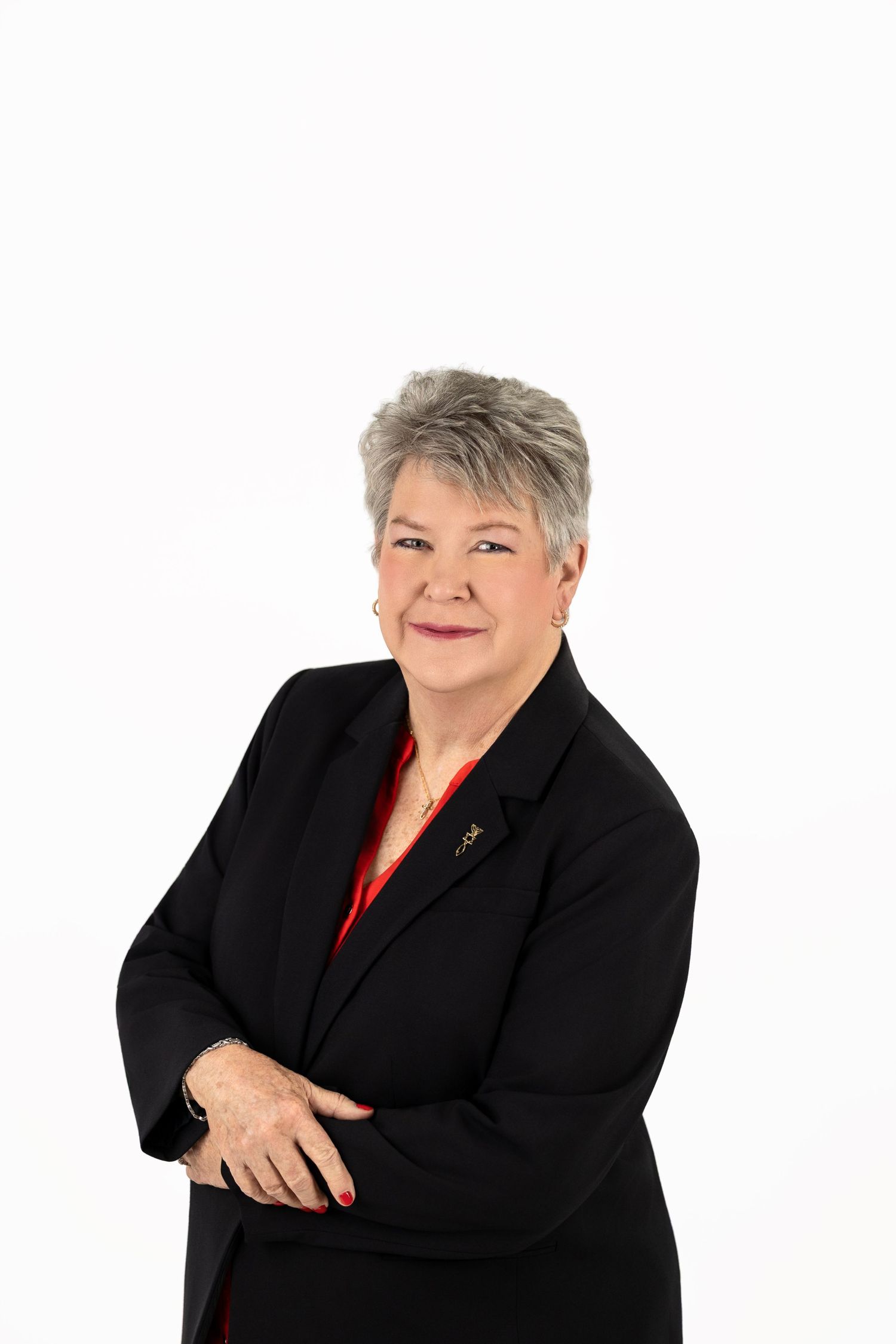 Professional headshot series showing a person in a black blazer and red top posing with different expressions against white.