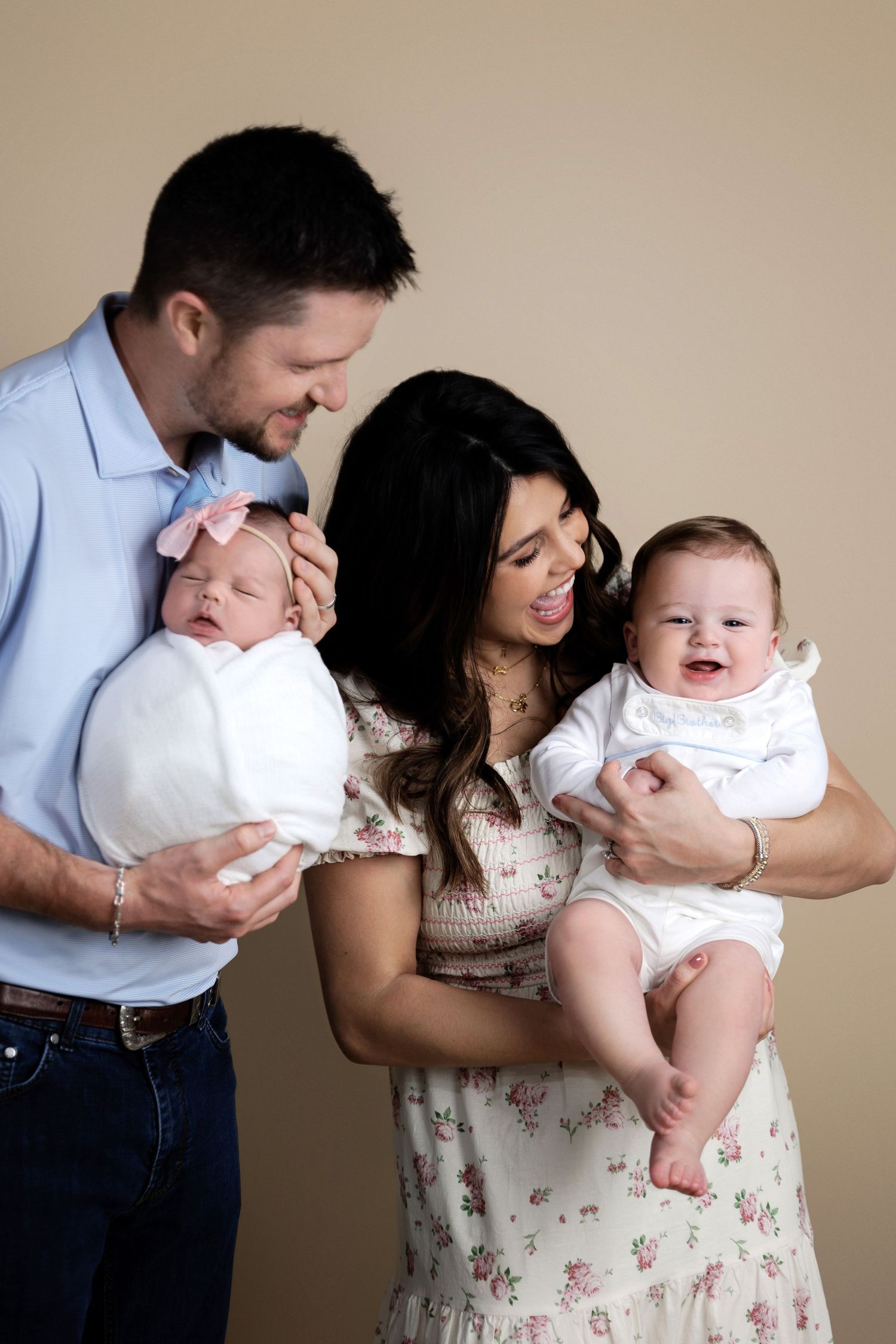 A couple in casual attire shares tender moments with their baby in a series of candid family portraits against a neutral background.