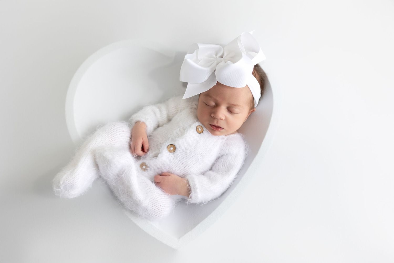 A minimalist white-themed photo series showing a sleeping baby in different poses on a light background.