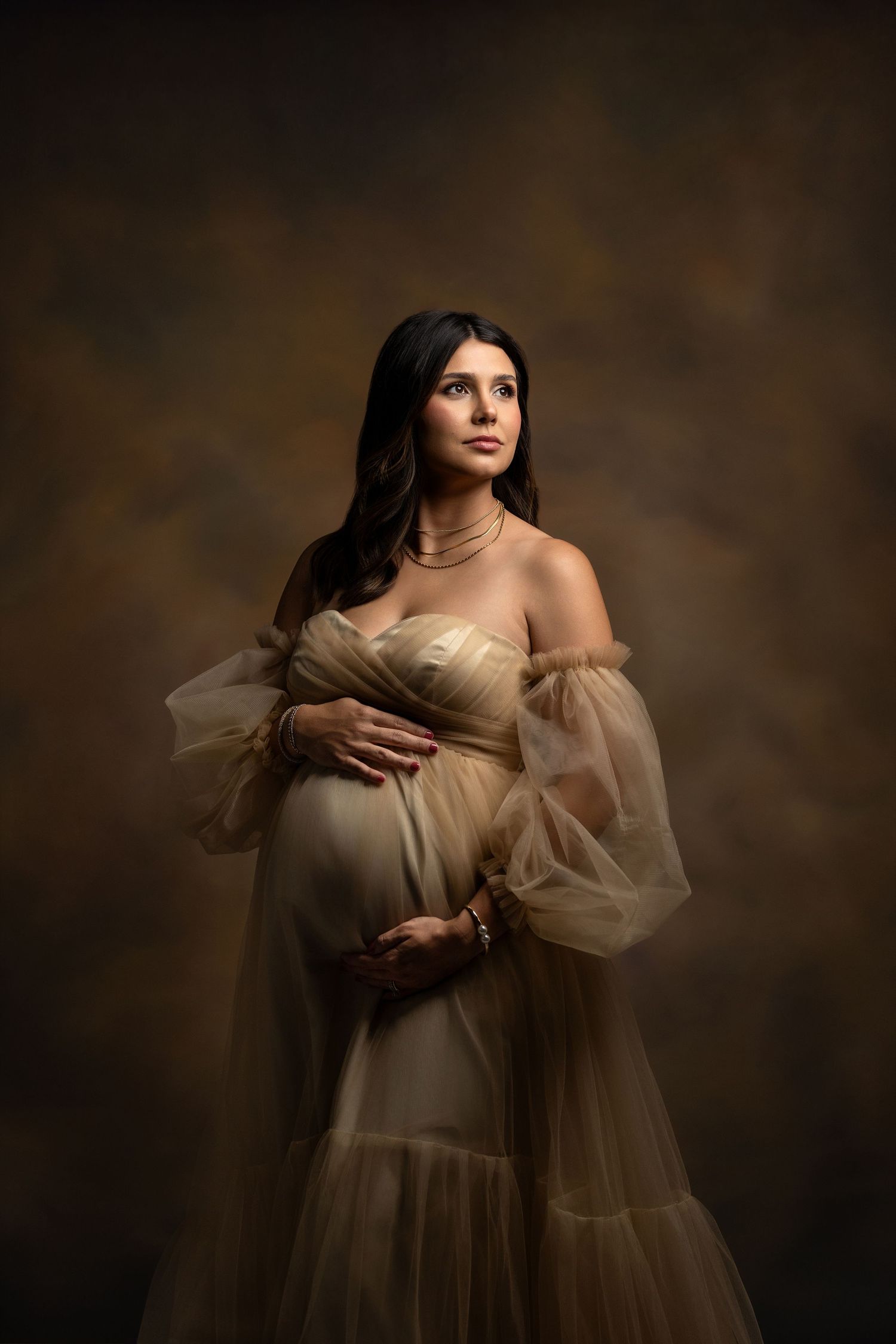 Artistic portrait series showing figure in ethereal cream tulle dress against dark moody background.
