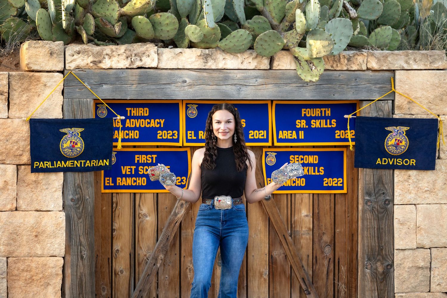 People standing behind wooden fence posts with FFA banners and blue jackets displayed across the top.