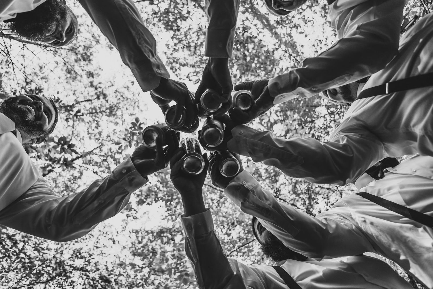 Black and white overhead view of people forming a circle with drinks.