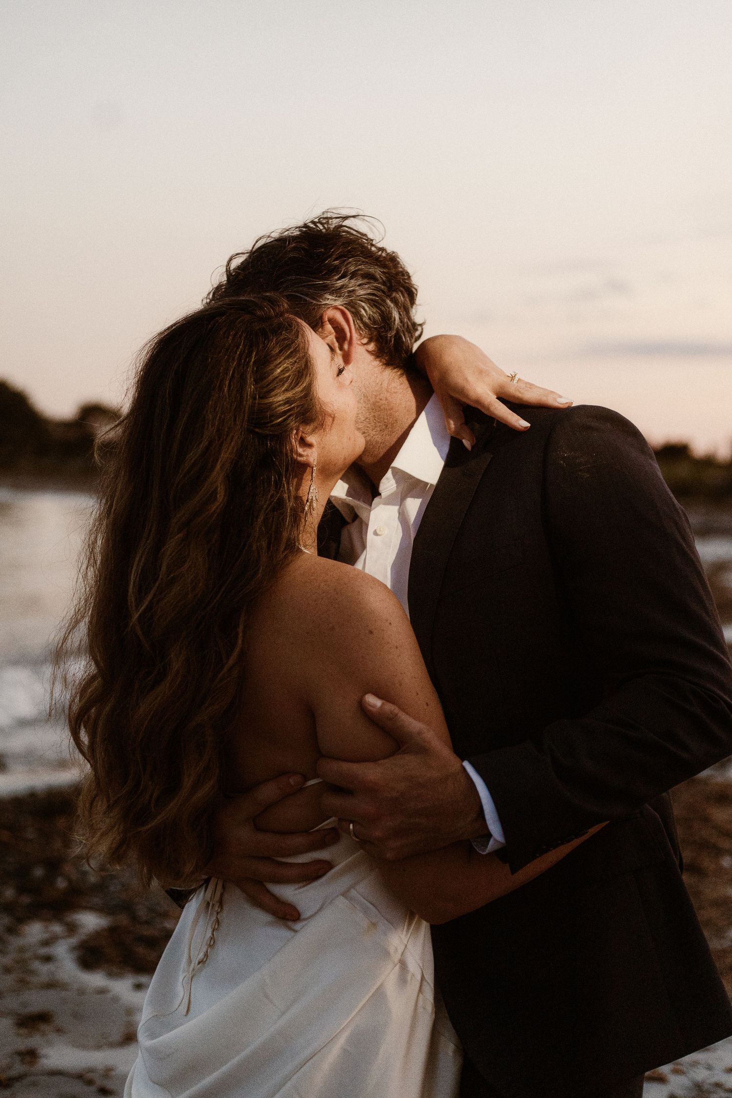 Romantic intimate moment between couple on a beach at sunset.