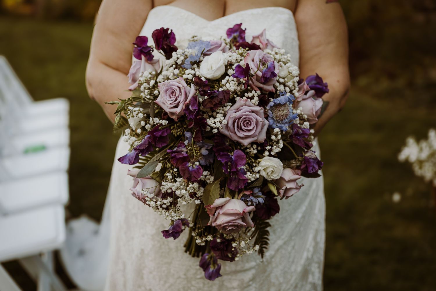 Elegant wedding bouquet featuring purple and mauve roses with mixed florals.